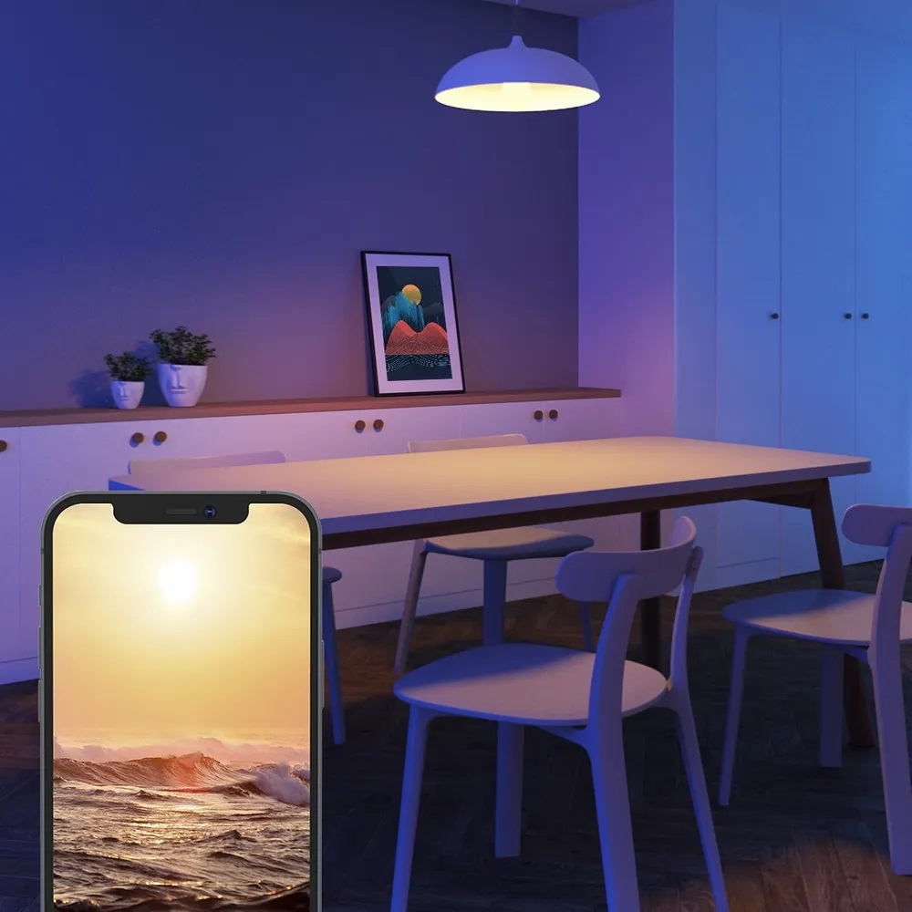 Smartfon z obrazem zachodu słońca obok stołu jadalnego.