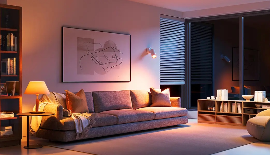 Przytulny salon z sofą, dziełami sztuki i oświetleniem otoczenia w nocy.
