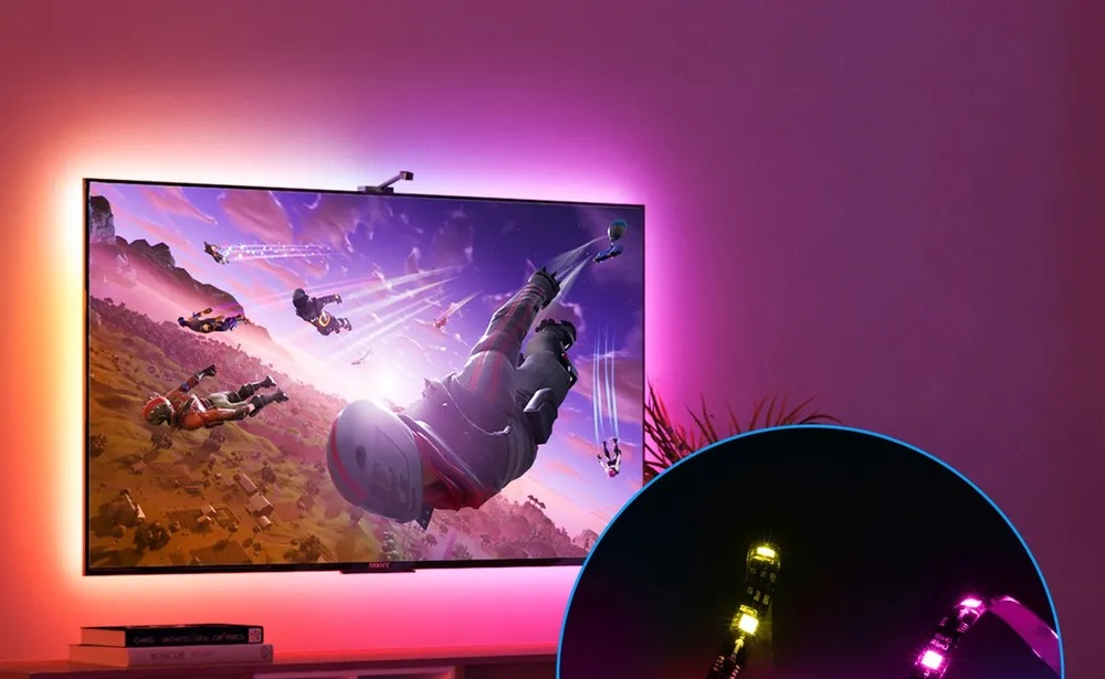 Telewizor wyświetlający scenę z gry z postaciami w powietrzu. Telewizor ma oświetlenie ambient.