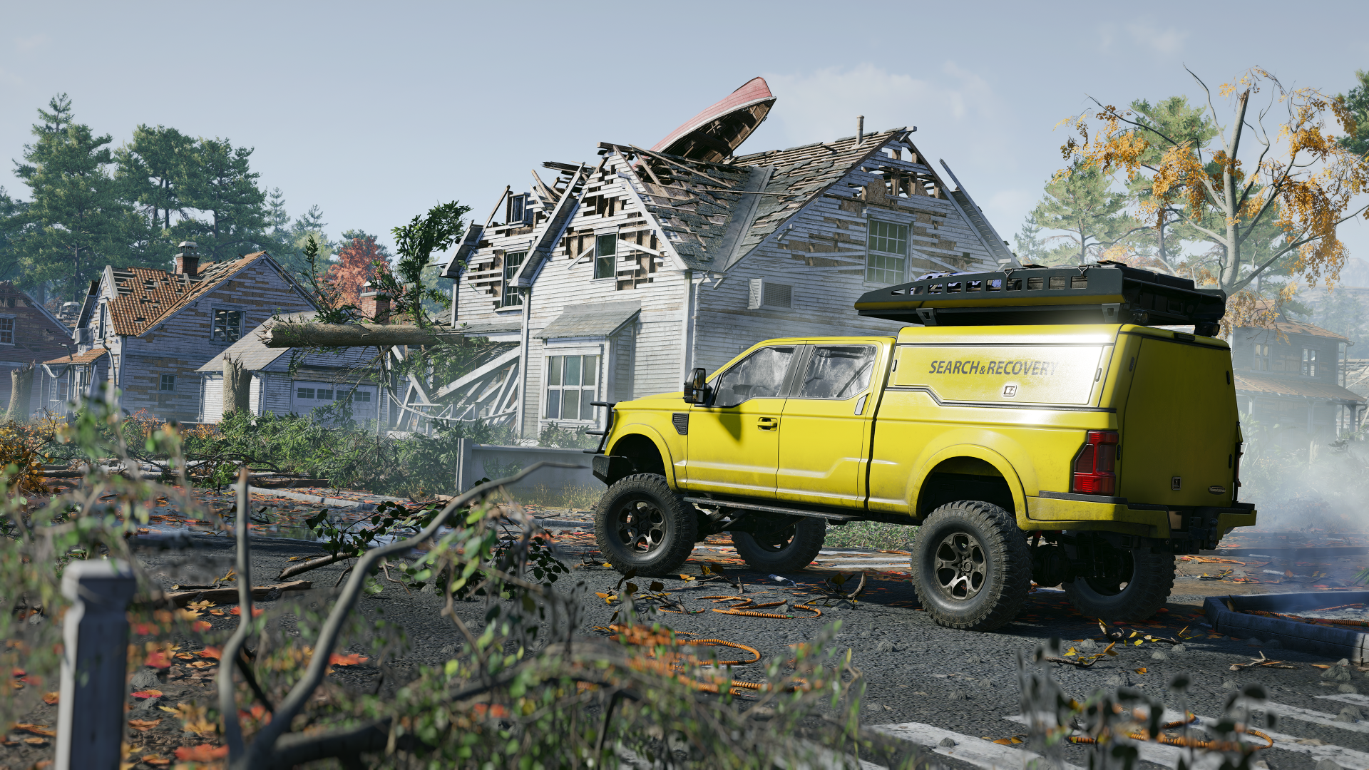 Żółta ciężarówka obok uszkodzonego domu. Łódź na dachu. Gruz na ziemi.