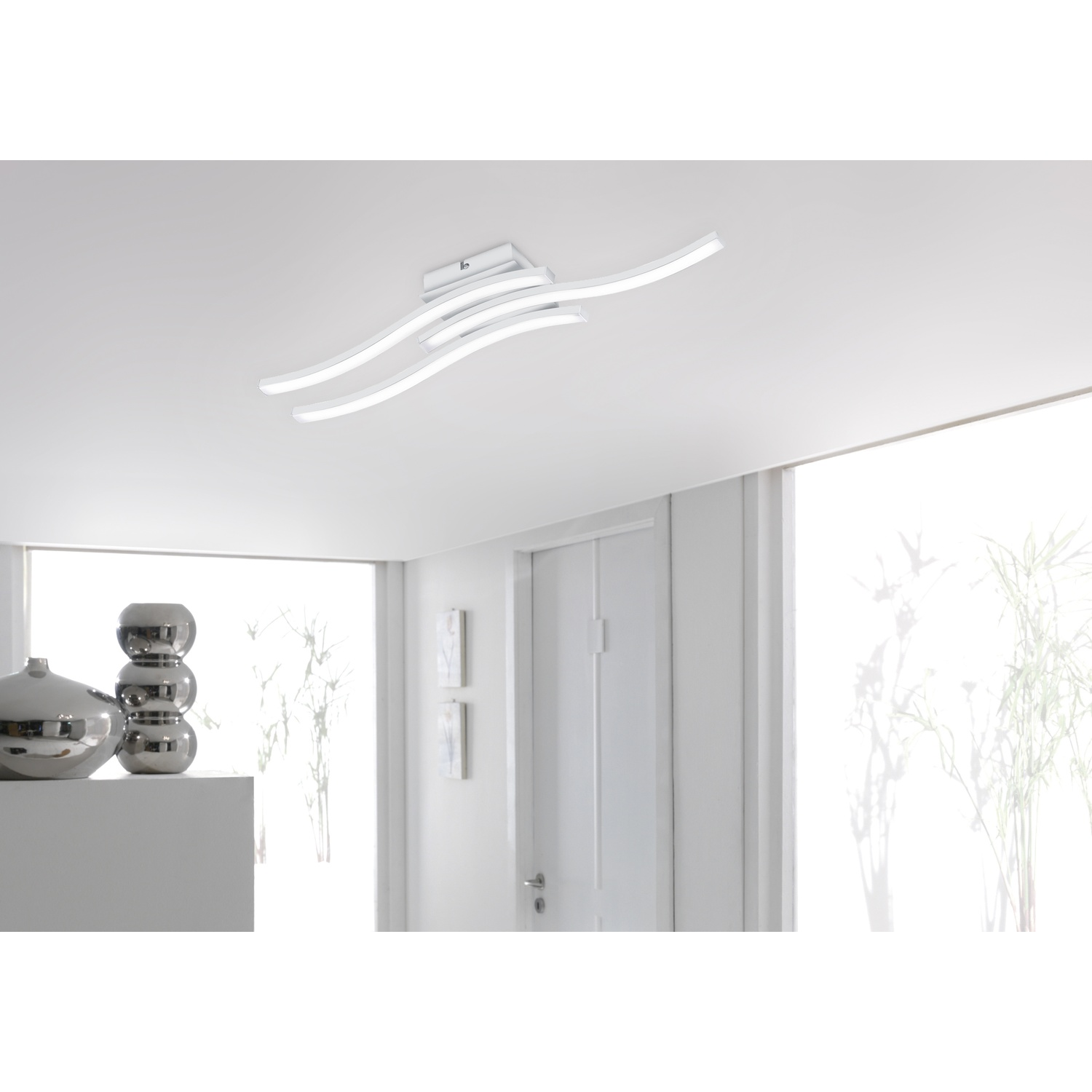 Moderna plafoniera bianca con luci LED curve. Pareti, porta e finestra bianche.