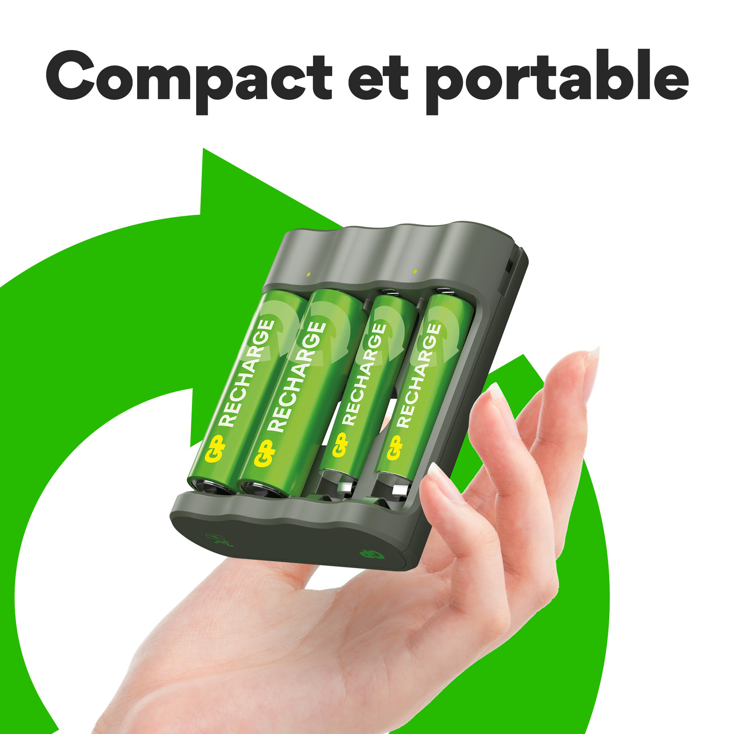 Main tenant un chargeur de batterie avec quatre piles vertes. Le fond est un symbole de recyclage vert.