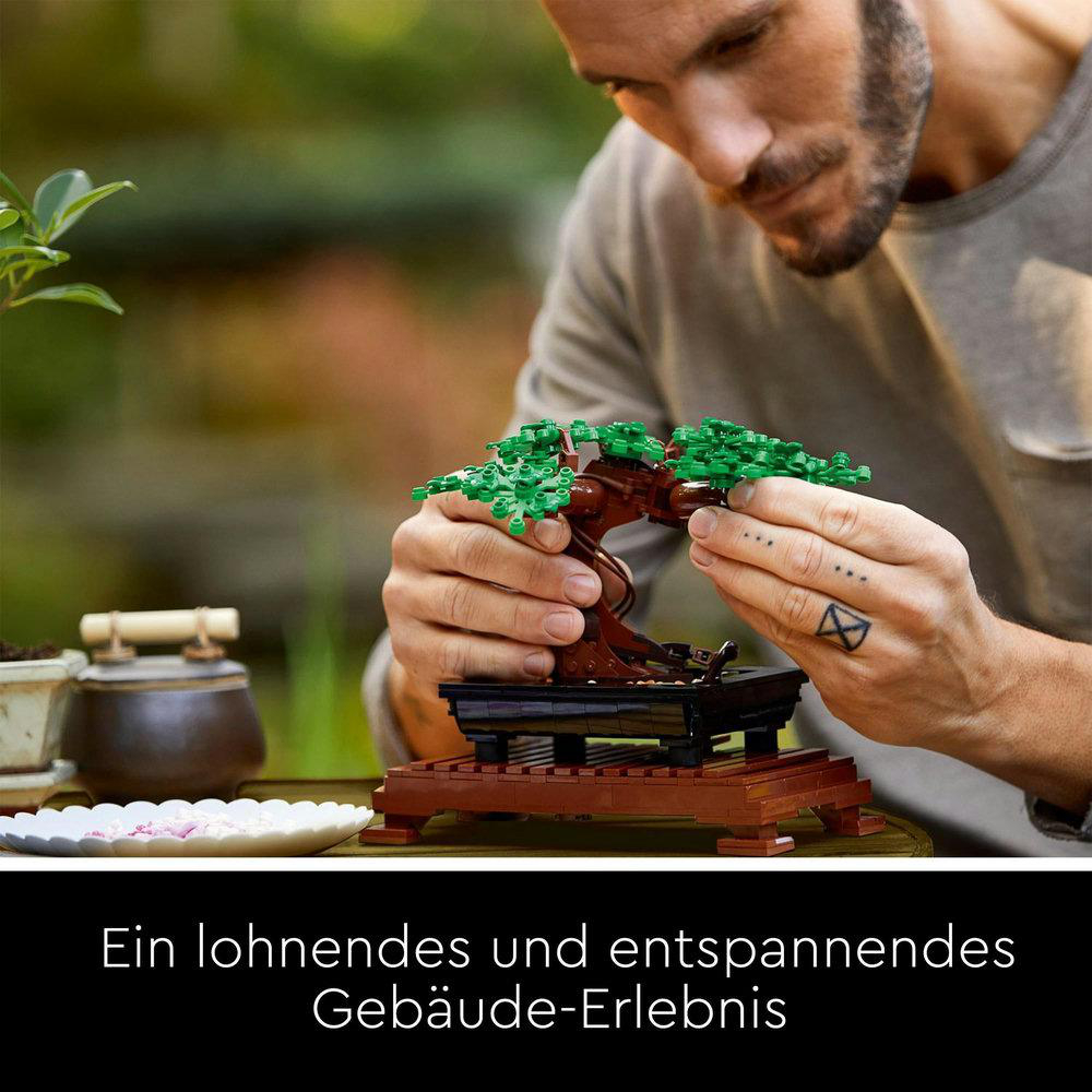 Eine Person baut einen Lego-Bonsai-Baum, mit Text auf Deutsch.