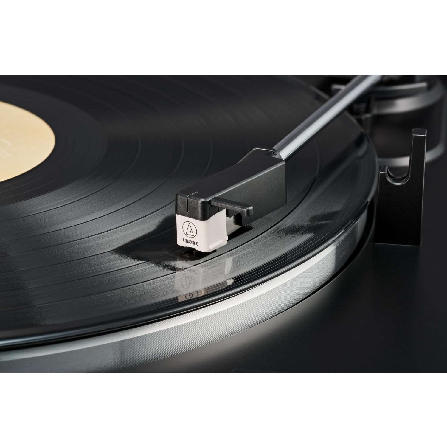 Primo piano dello stilo di un giradischi su un disco in vinile nero. Sfondo nero.