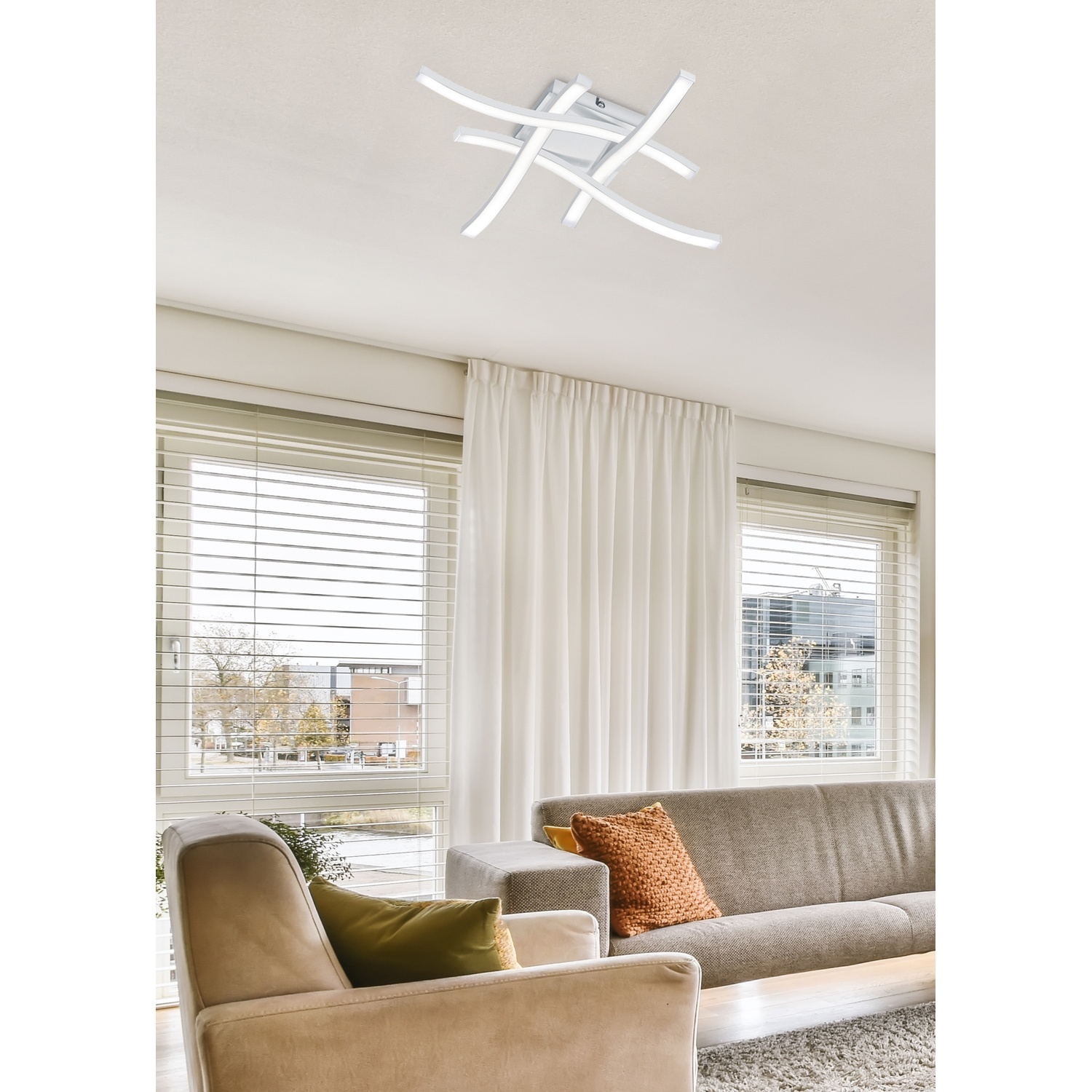 Soggiorno con moderna lampada da soffitto bianca. Visibili anche divano, poltrona, tende e finestra.