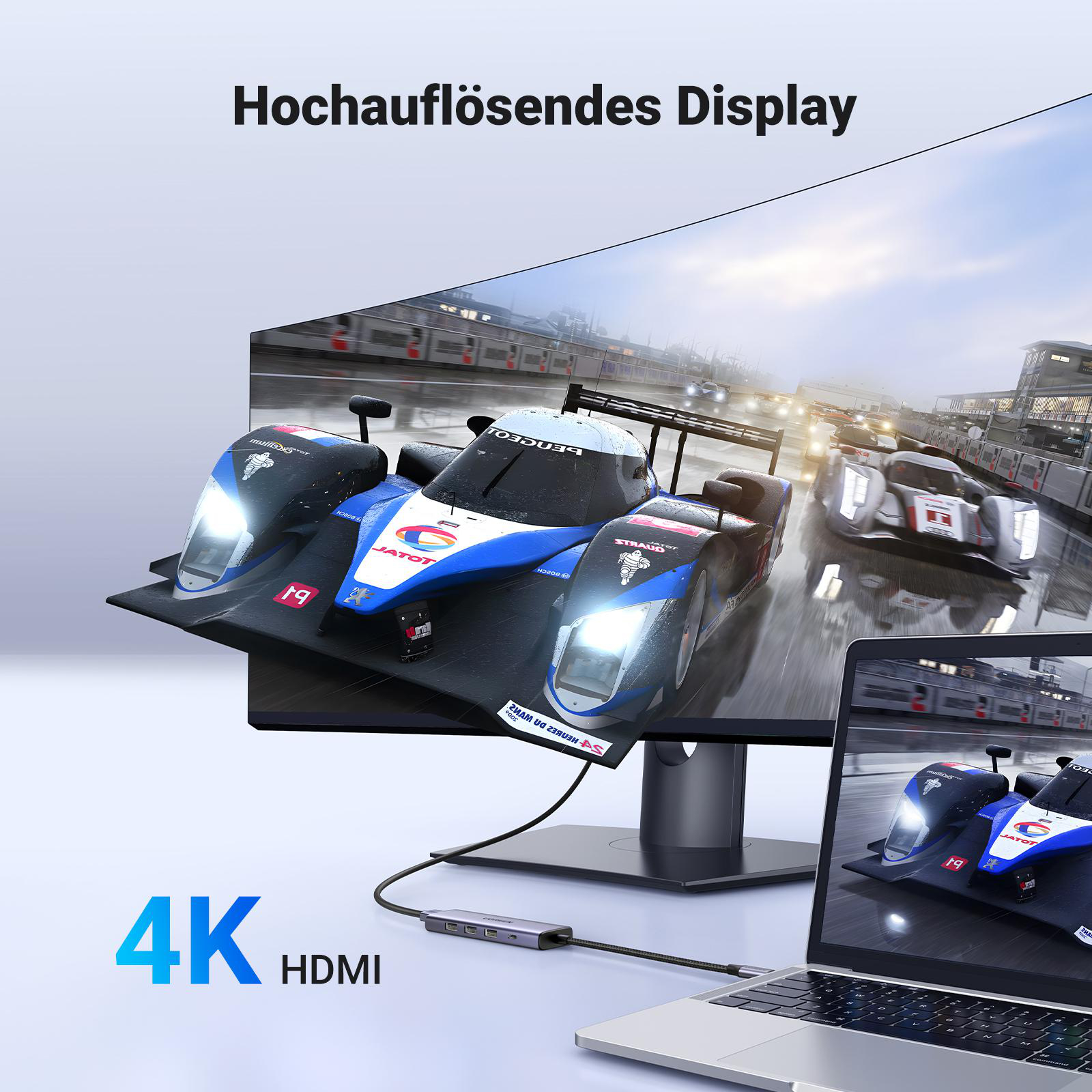 Ein Monitor, der eine Rennwagenszene anzeigt, mit Laptop und Hub.