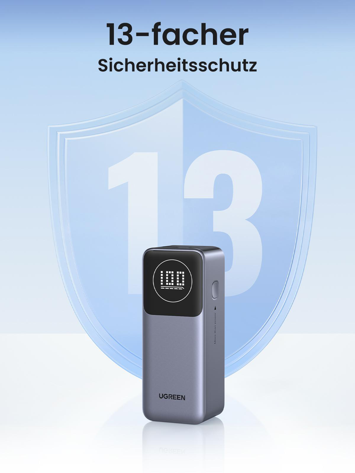 Eine graue Powerbank mit Display vor einem Schild mit der Zahl 13.