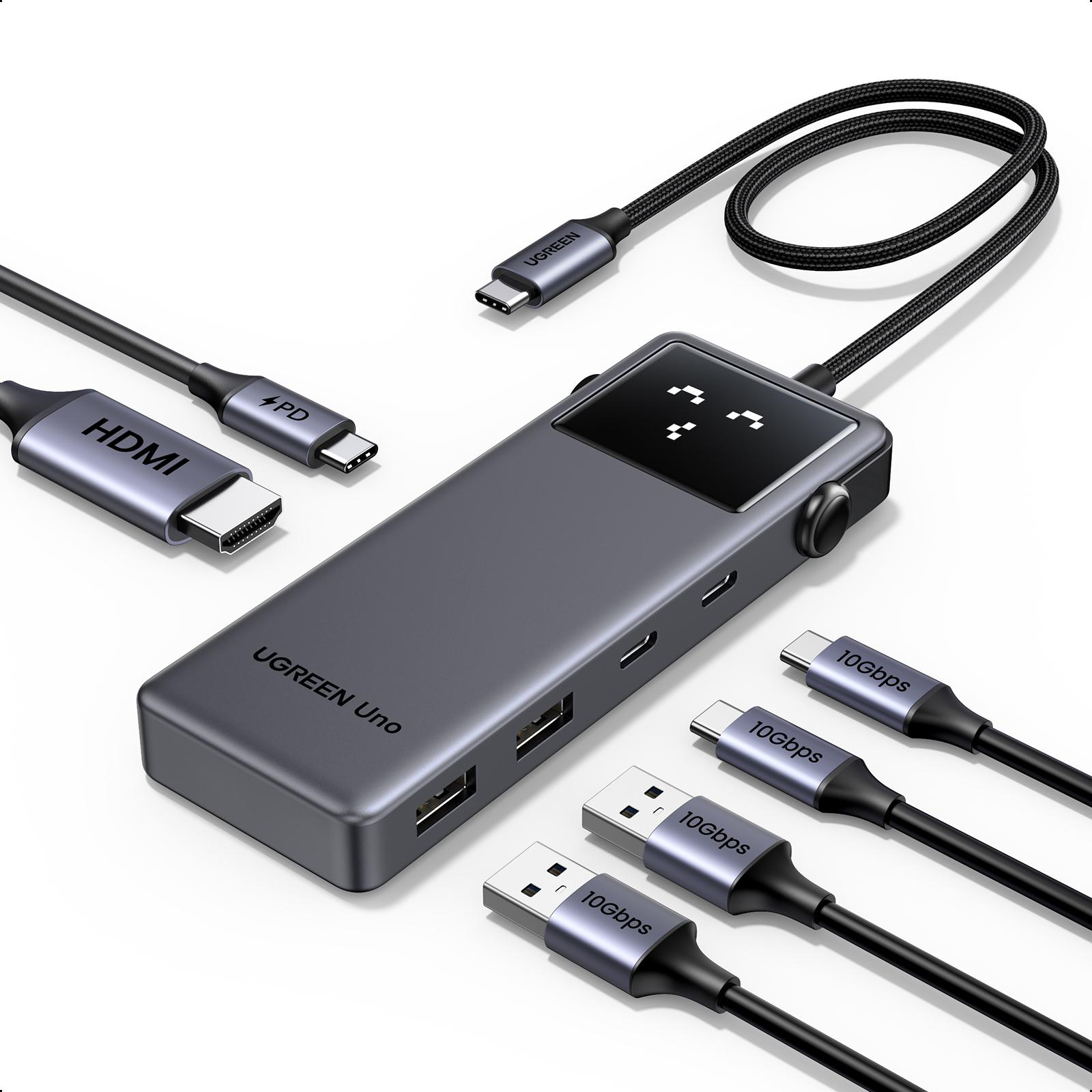 Ein grauer UGREEN Uno Hub mit mehreren USB-Anschlüssen und angeschlossenen Kabeln auf weißem Grund.