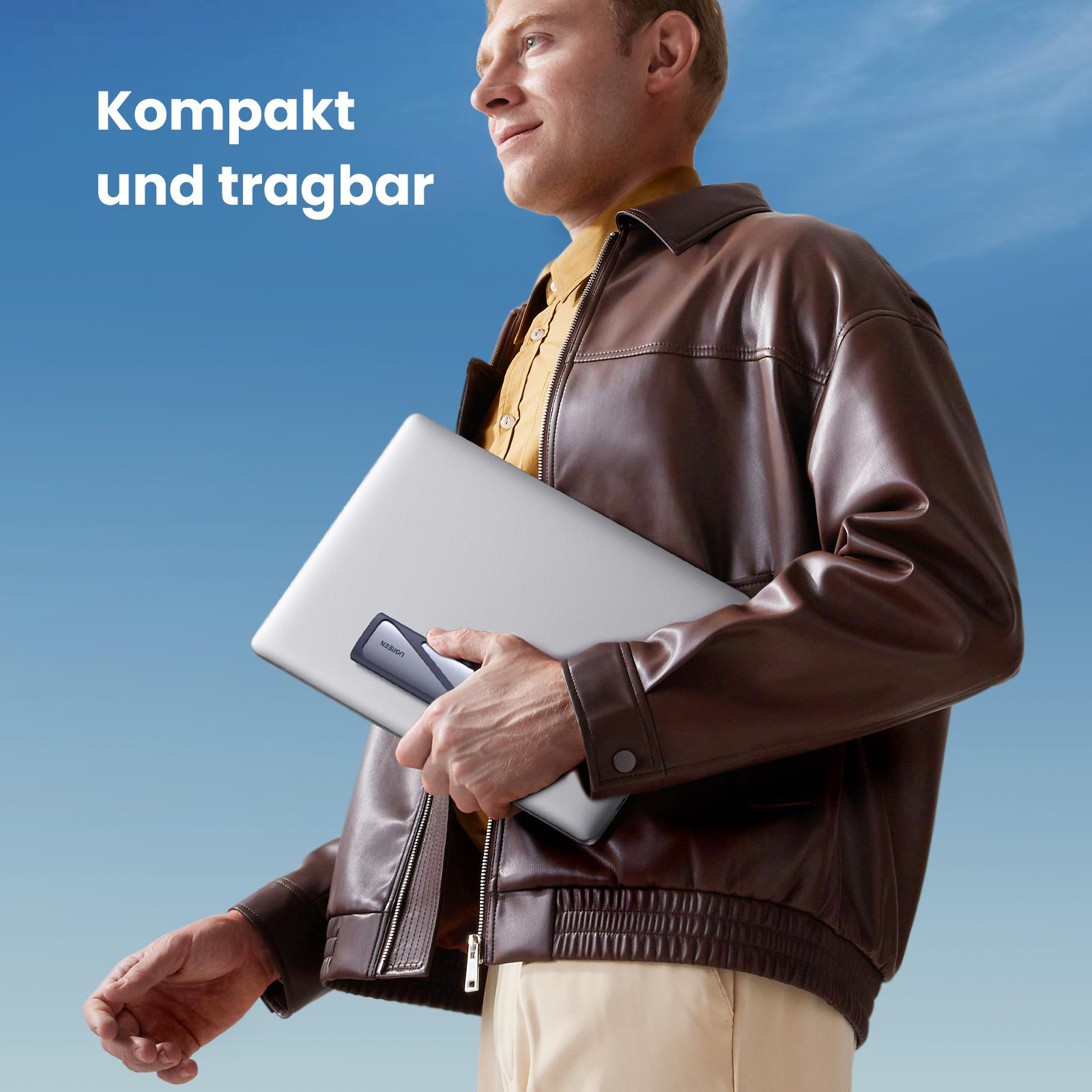 Mann hält einen Laptop mit einem Hub darauf. Text oben sagt 'Kompakt und tragbar'.