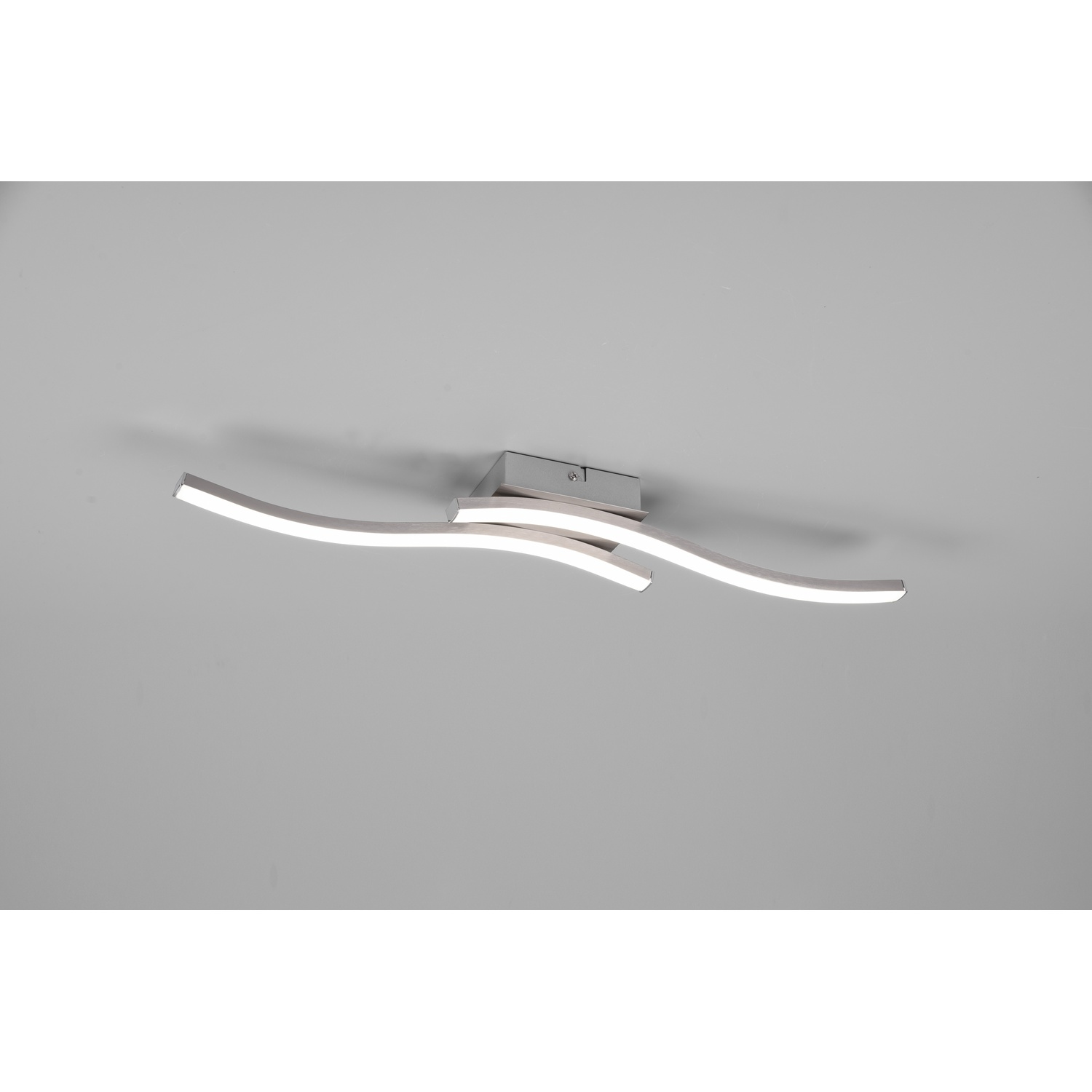 Plafoniera moderna con tre barre curve illuminate, montata su un soffitto grigio chiaro.