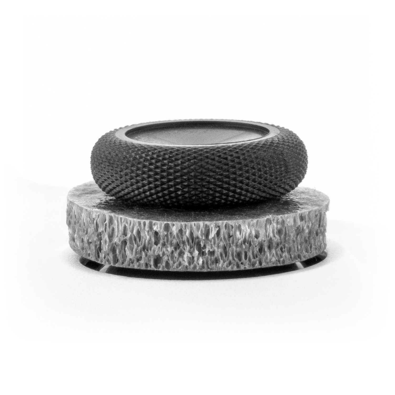 Black and silver decorative object on a white background, looks like a ring.