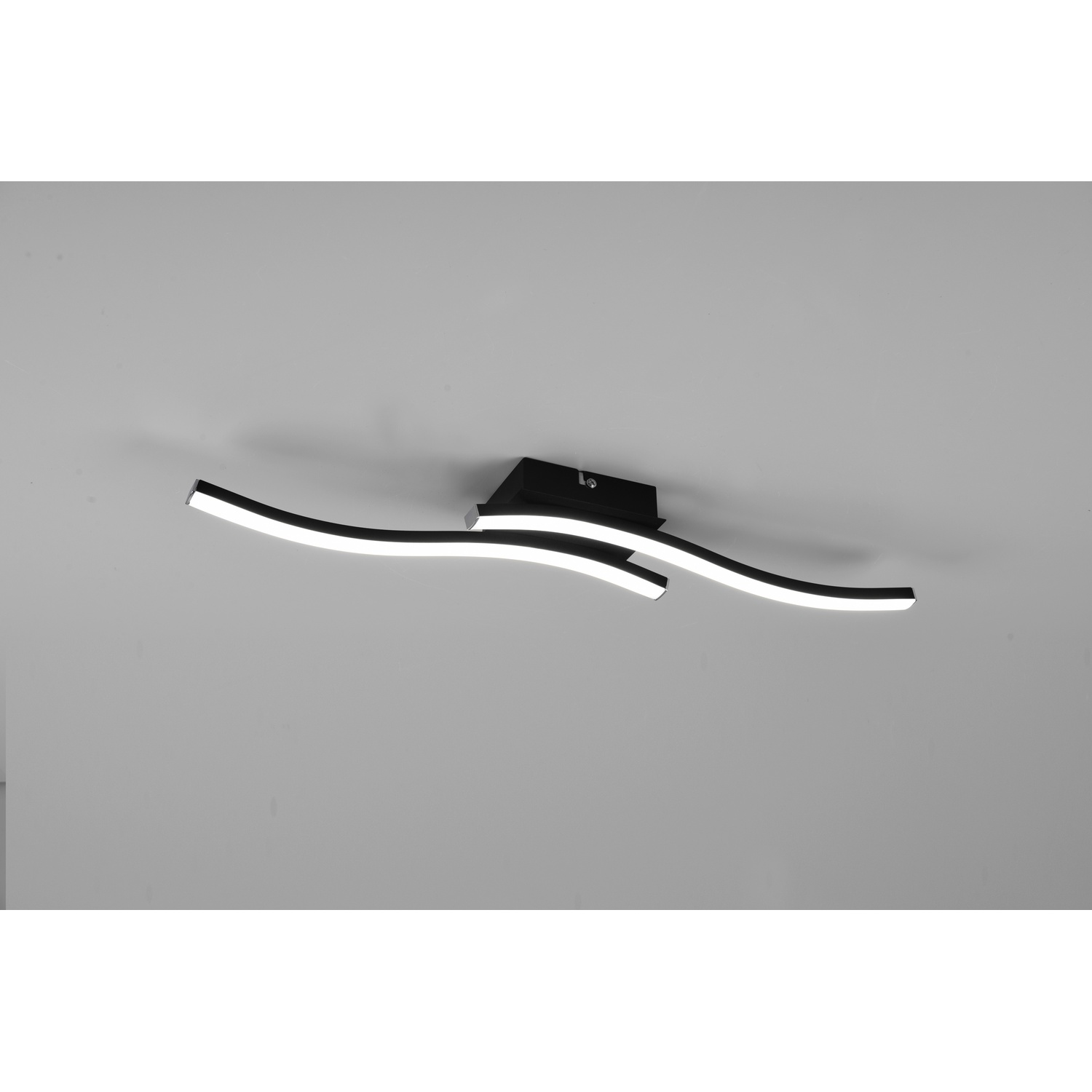 Lampada da soffitto con tre strisce LED nere curve con luce bianca su sfondo grigio.