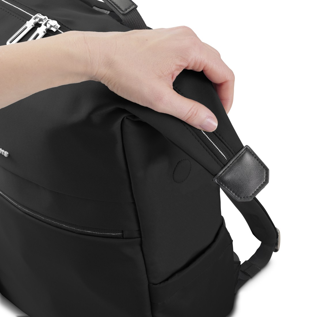 Eine Hand hält den Griff einer schwarzen Tasche vor weißem Hintergrund.