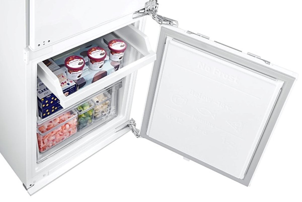 Zbliżenie na komorę zamrażarki z lodami i innymi mrożonkami. Drzwi są otwarte.