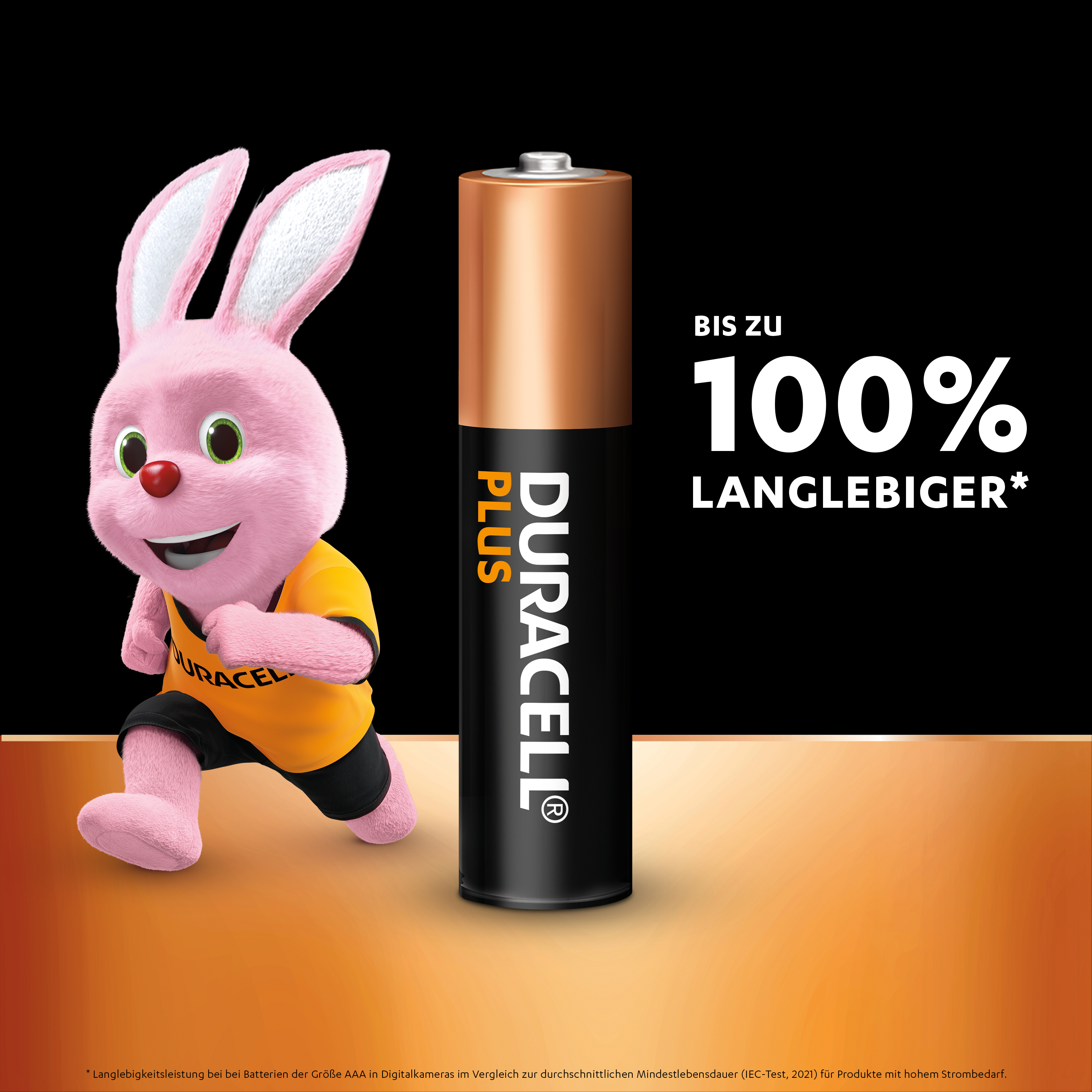 Rosa Hase rennt auf eine Duracell Plus Batterie zu. Schwarzer Hintergrund mit orangefarbenen Akzenten.