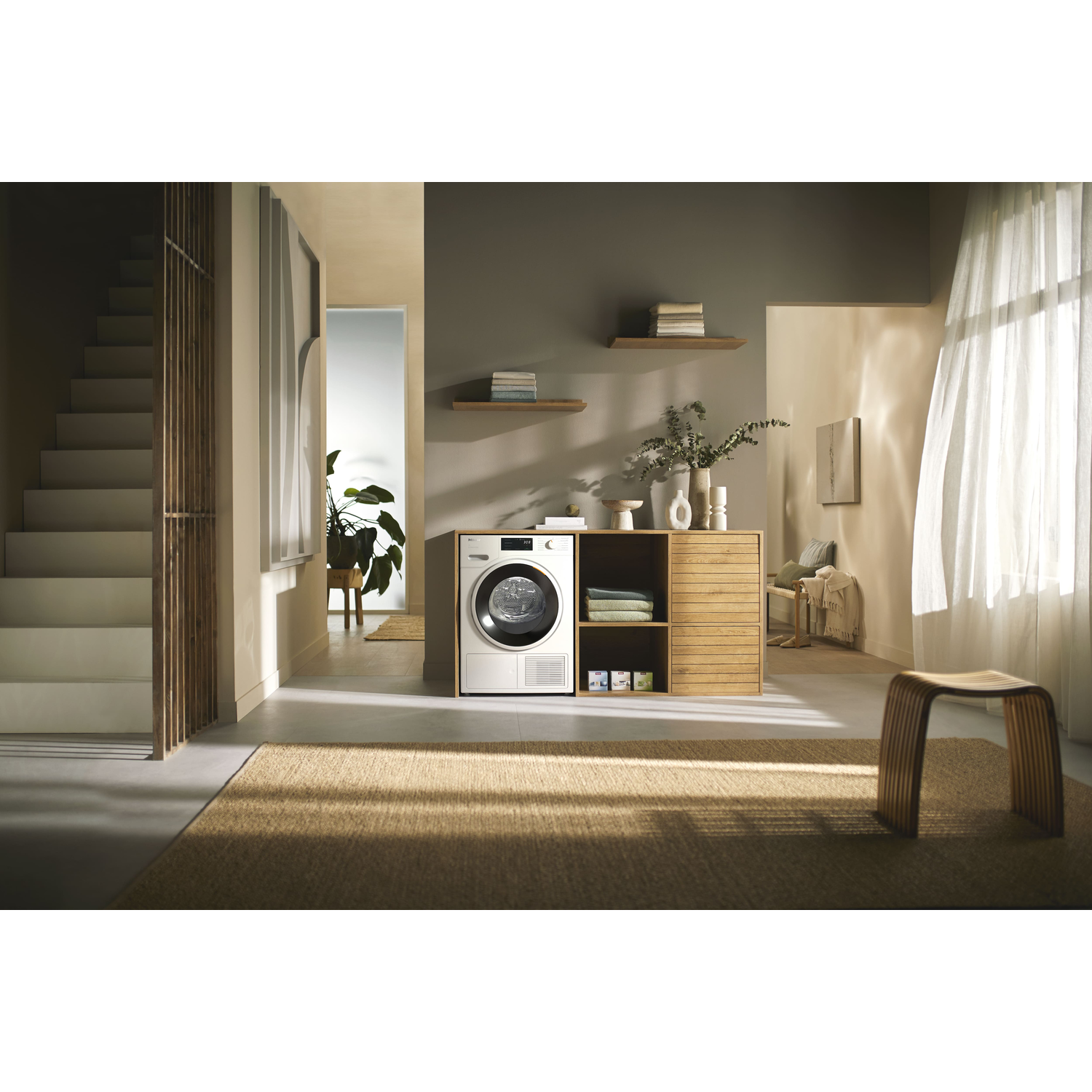 A laundry room scene with a washing machine and a drying rack.