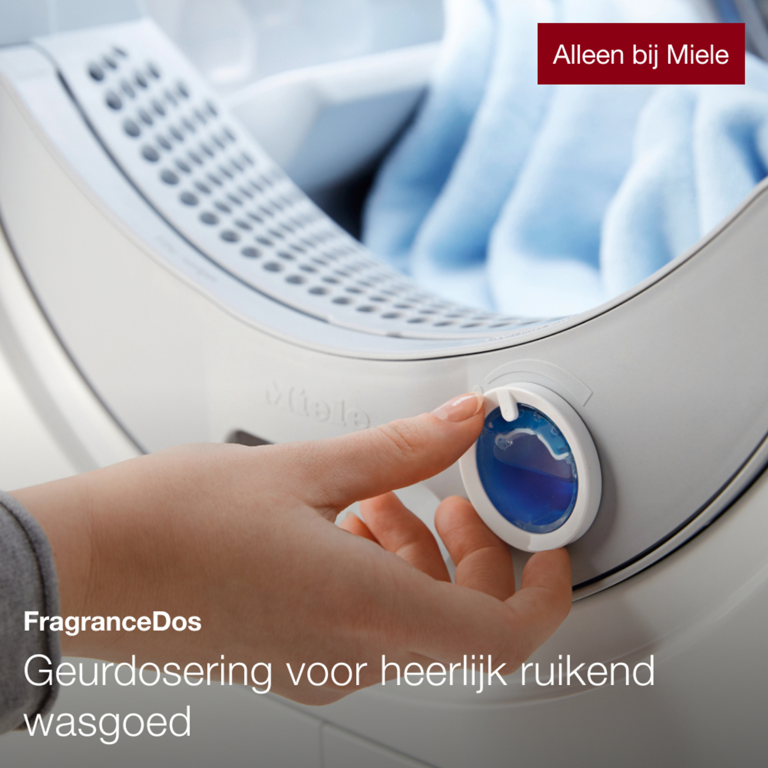 A hand adding perfume to the washing machine.