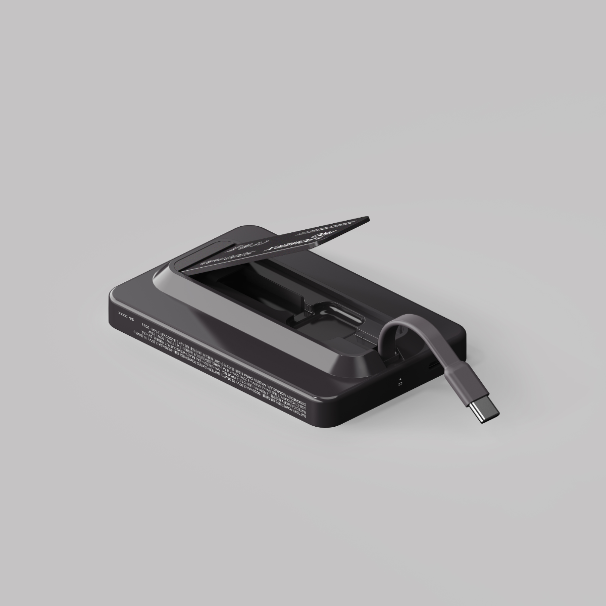 USB-C kablosu takılı siyah cihaz. Gri zemin.