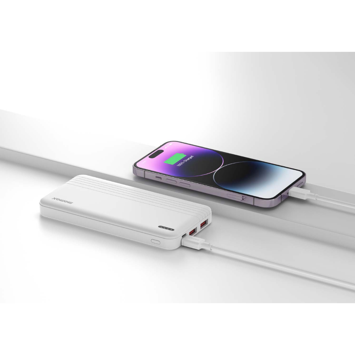 Beyaz powerbank bir telefonu şarj ediyor. Telefon %100 şarj gösteriyor.