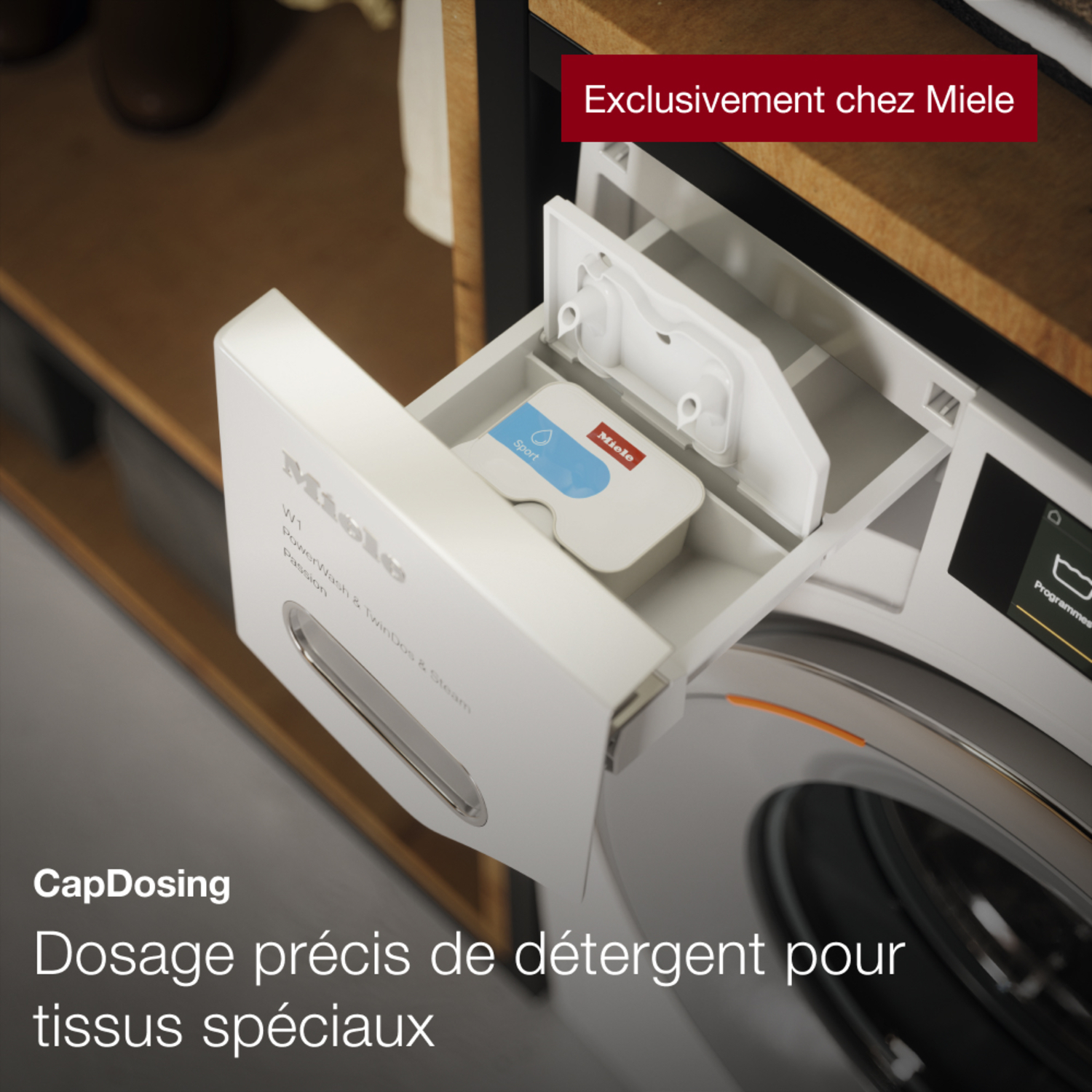 Machine à laver blanche avec un distributeur de détergent, le tiroir est ouvert. Texte dit 'Miele'.