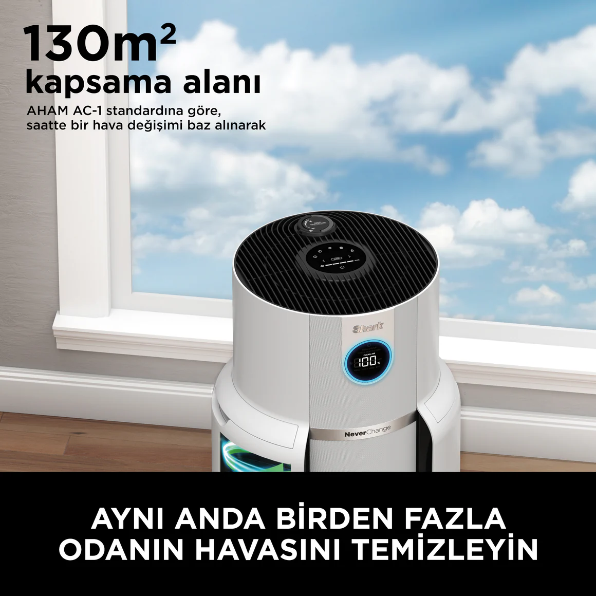 Mavi gökyüzü olan bir pencerenin yanında beyaz bir hava temizleyici.