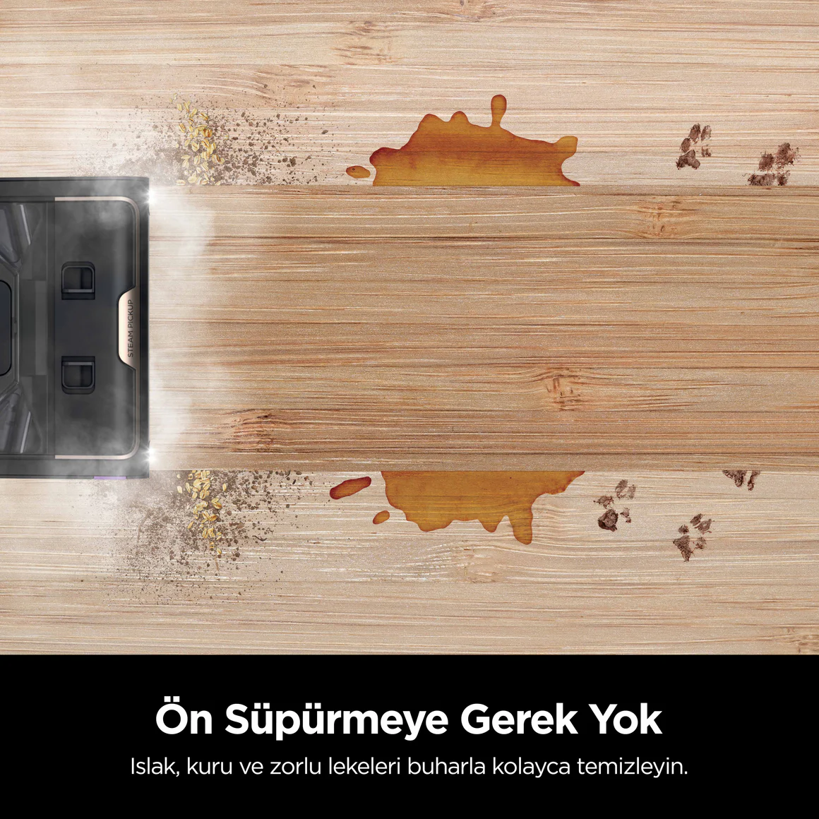 Siyah bir robot süpürge, ahşap bir zemini temizliyor. Dökülmeler ve pati izleri var.