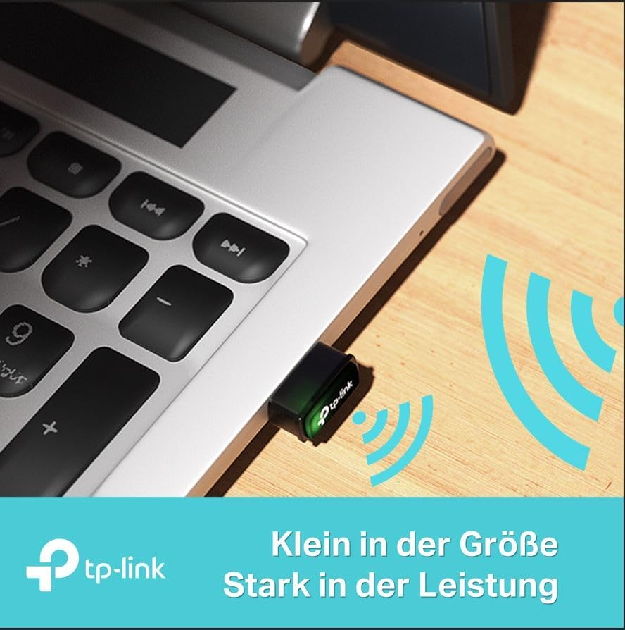 Ein Laptop mit einem tp-link WLAN-Adapter, der eingesteckt ist, mit WLAN-Symbolen rechts.