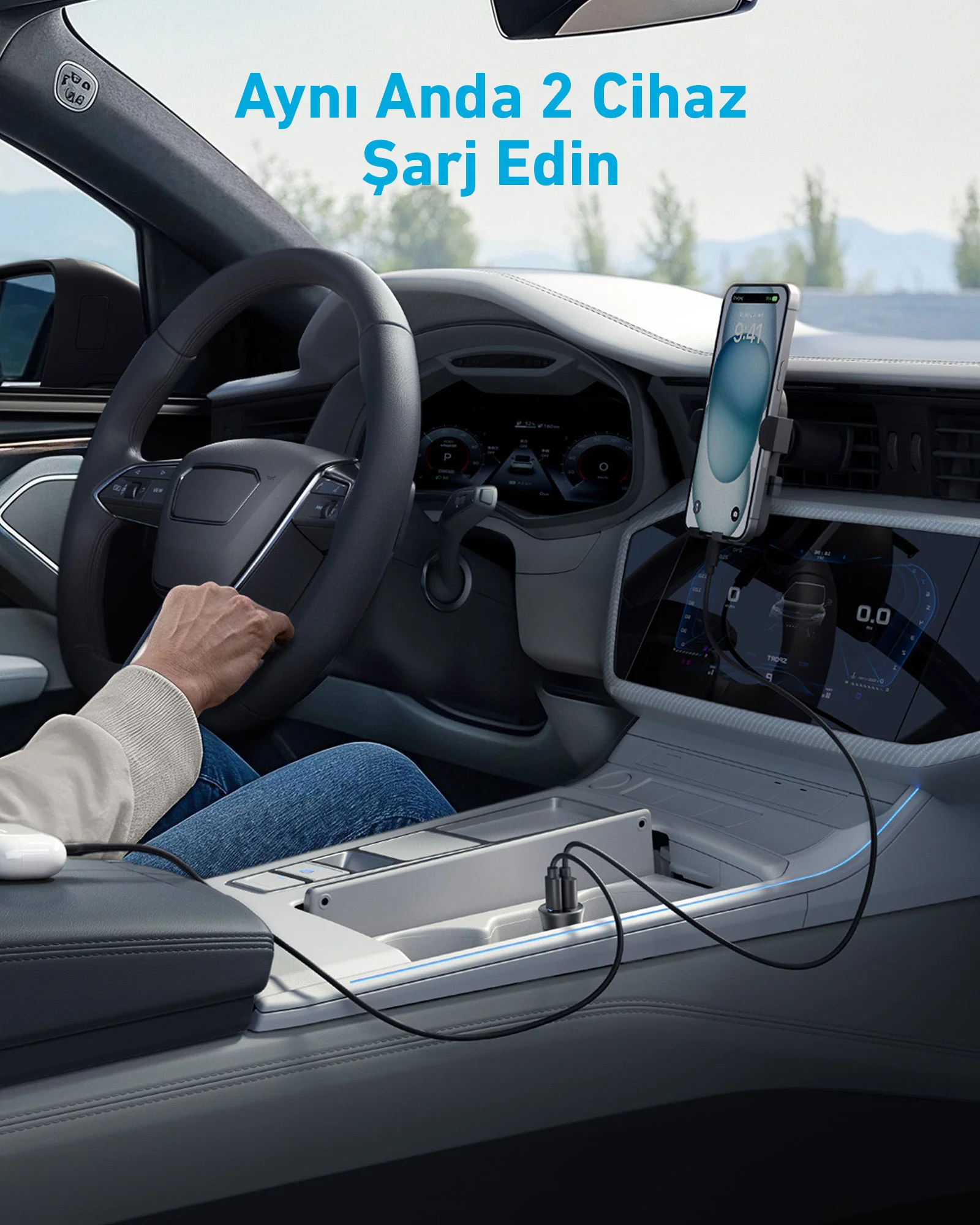 Bir telefonun şarj edildiği ve sürücünün olduğu bir araba içi.