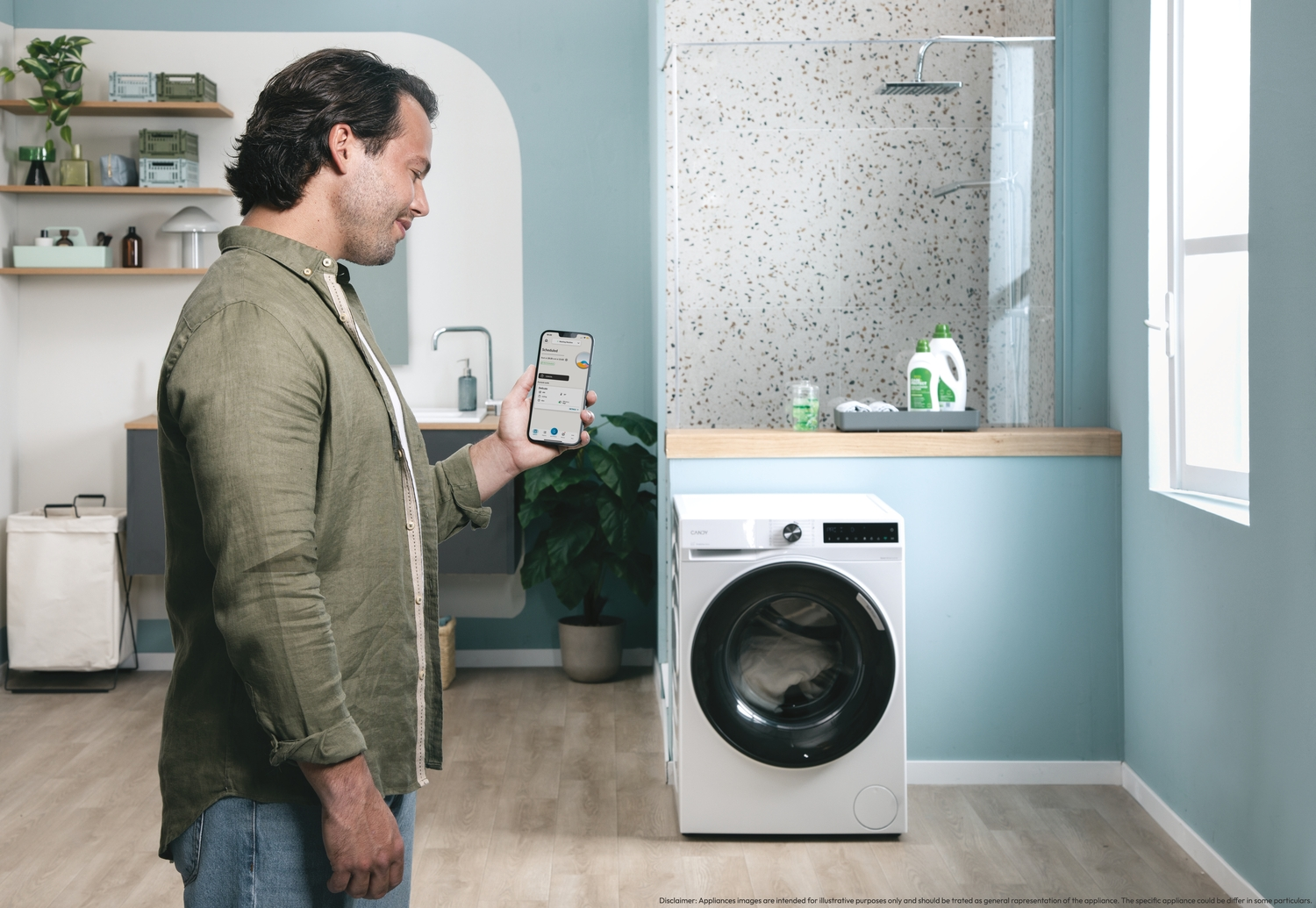 Hombre usando un smartphone en un lavadero. Lavadora a la derecha. Baño en el fondo.