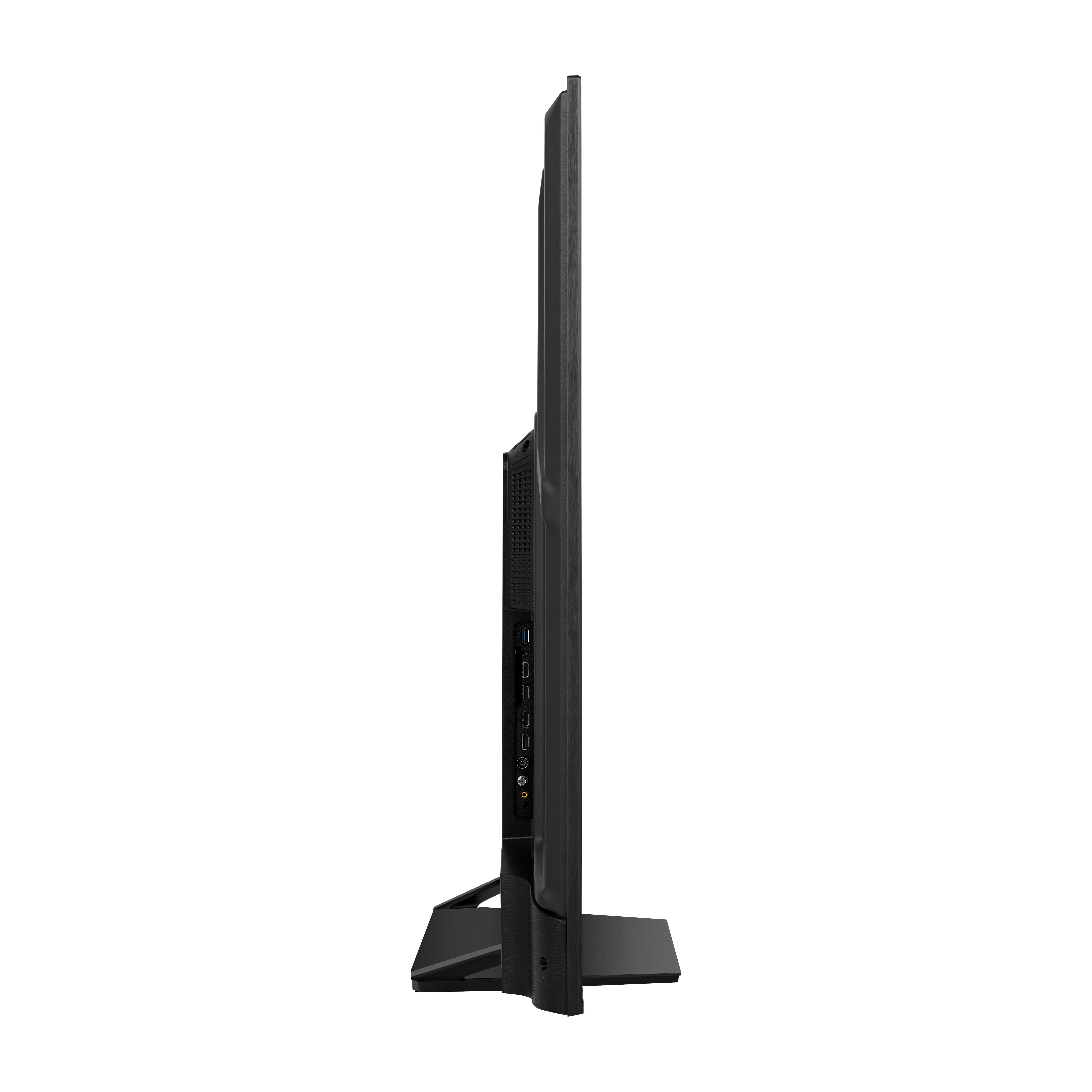 Ein schwarzer Fernseher, von der Seite betrachtet. Er steht auf einem Ständer und hat viele Anschlüsse.