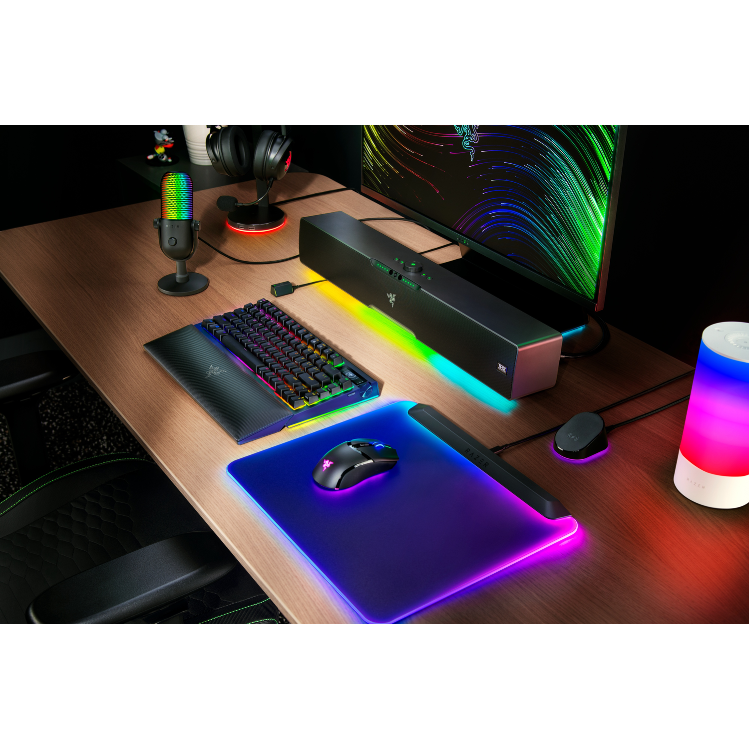Bureau-opstelling: toetsenbord, muis, soundbar, microfoon en lamp. De scène heeft een donkere esthetiek.