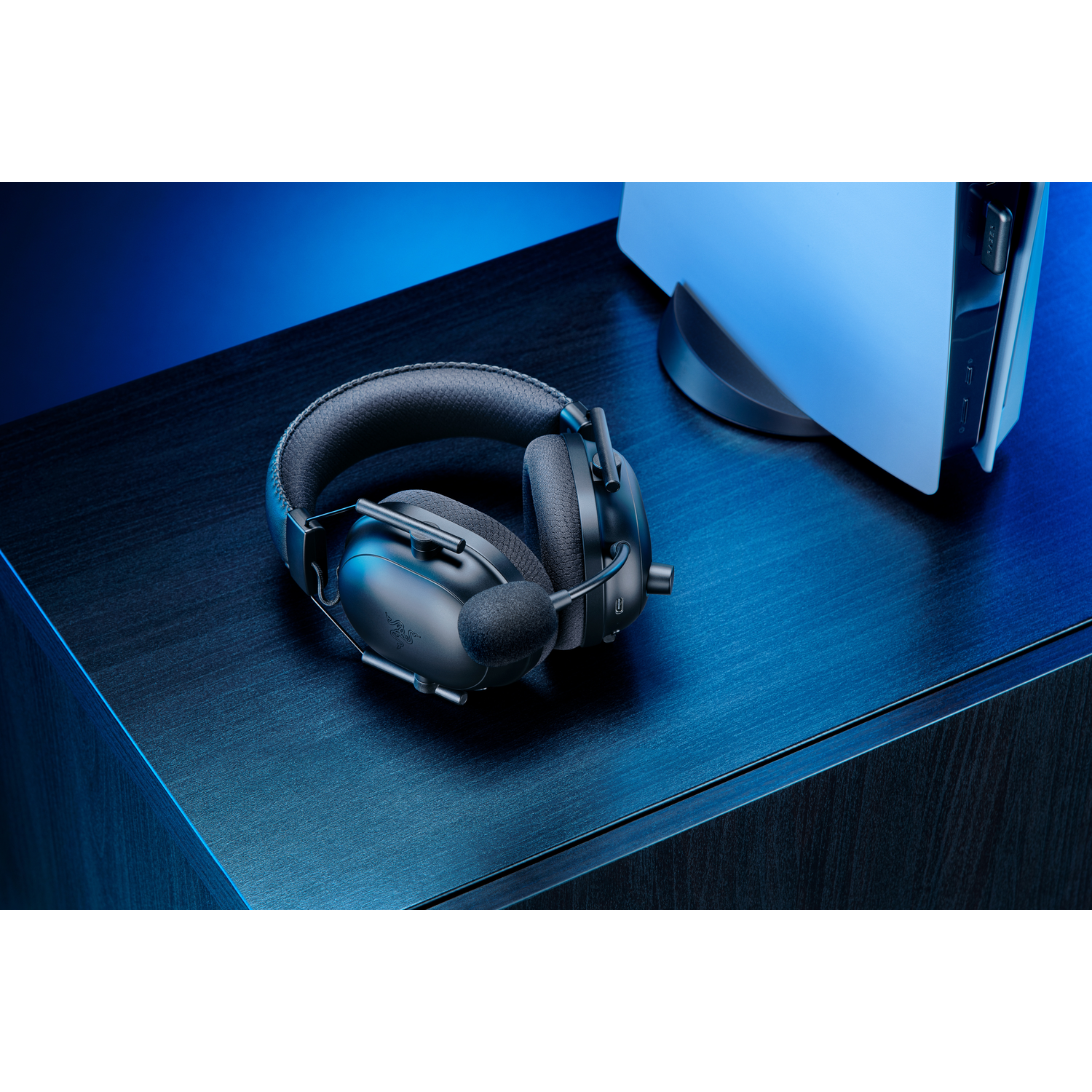 Casque sur un bureau à côté d'une console de jeu blanche.