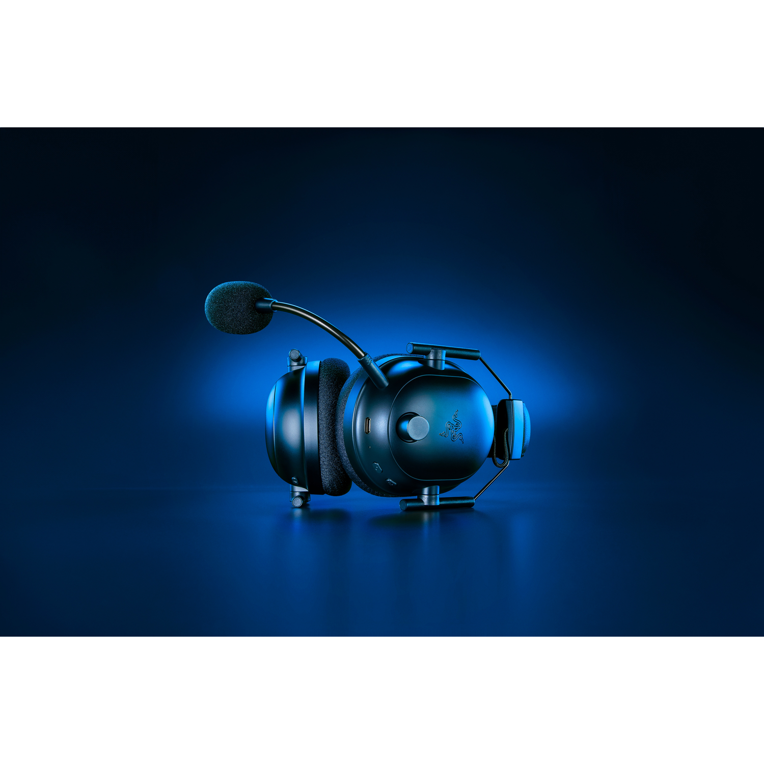 Casque noir avec microphone. Ils sont posés sur un fond bleu foncé, avec un éclairage bleu.