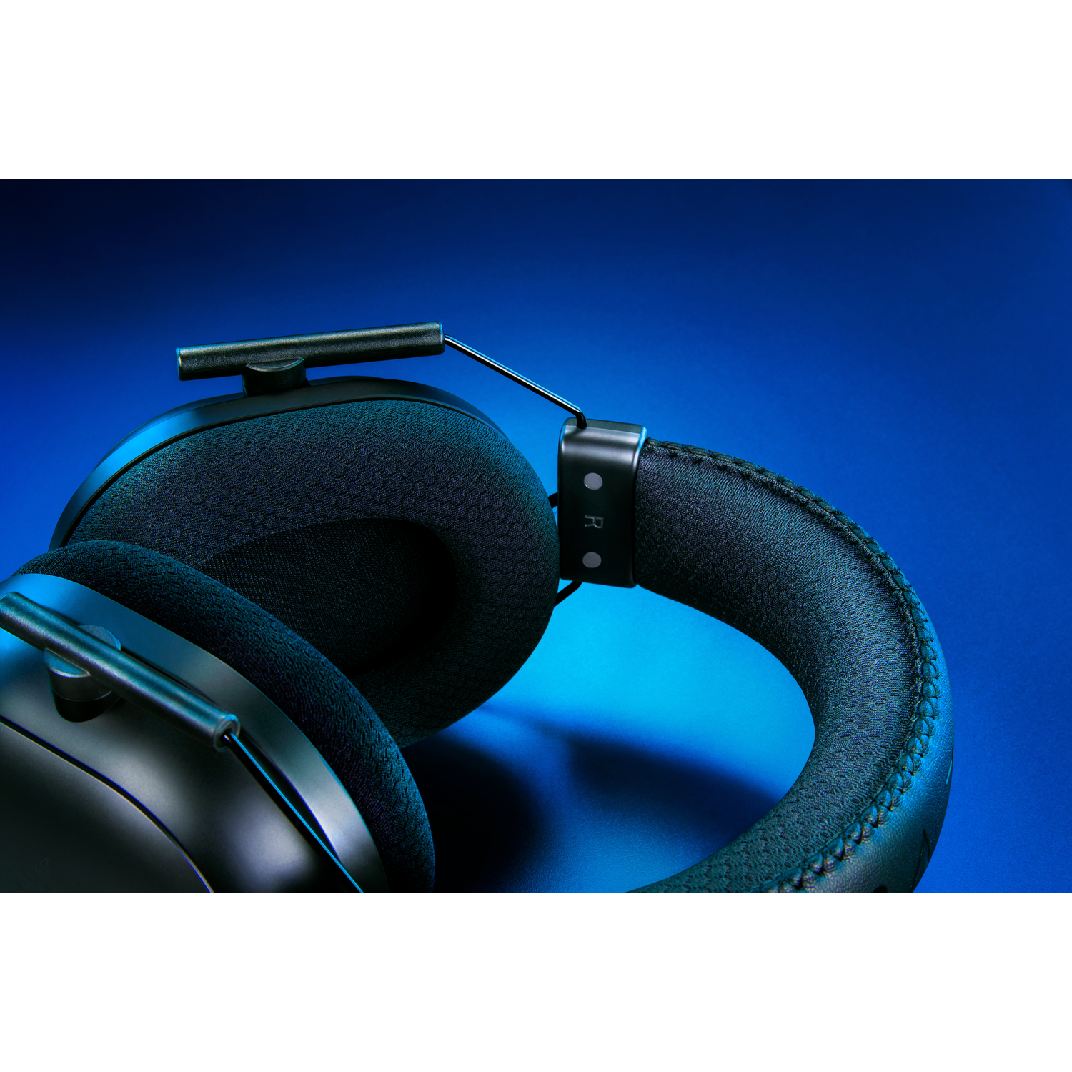 Casque noir sur fond dégradé bleu, avec une vue rapprochée des oreillettes.