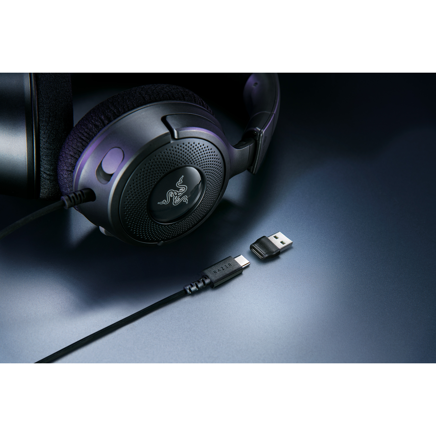 Black headphones with a Razer logo, cable and USB adaptor.