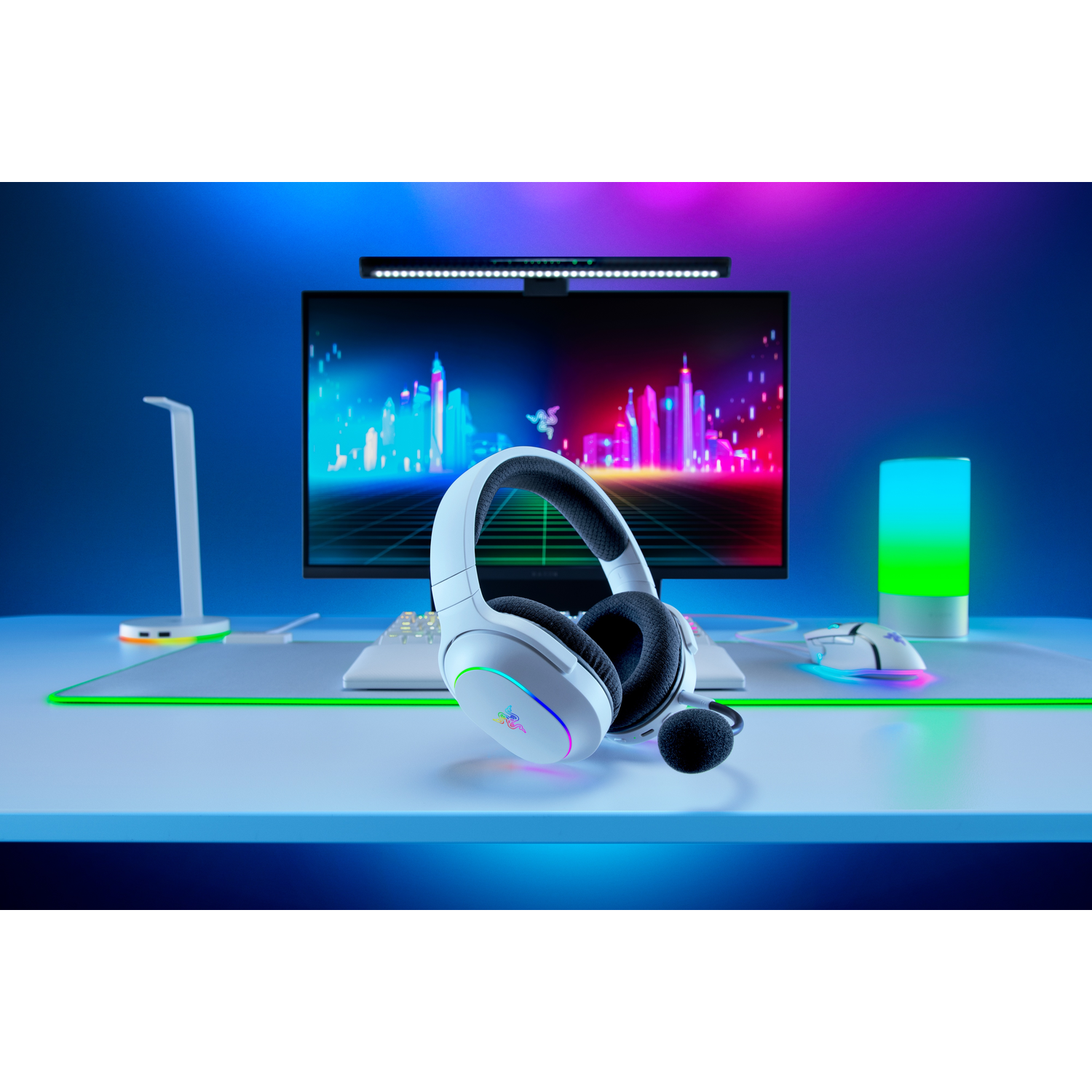 Witte gaming headset op bureau met monitor, muis en verlichting.