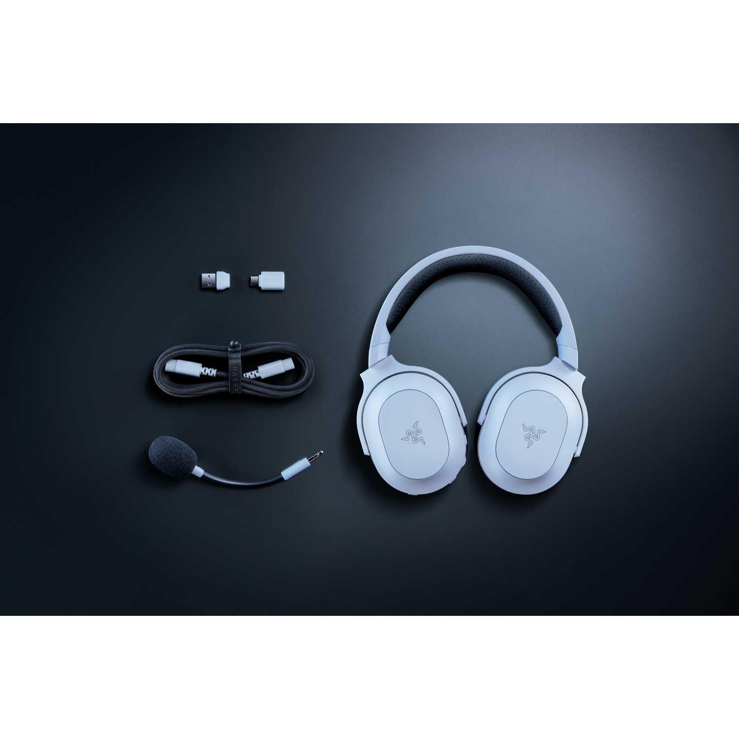 Een set witte gaming-hoofdtelefoon met accessoires, op een donkere achtergrond.