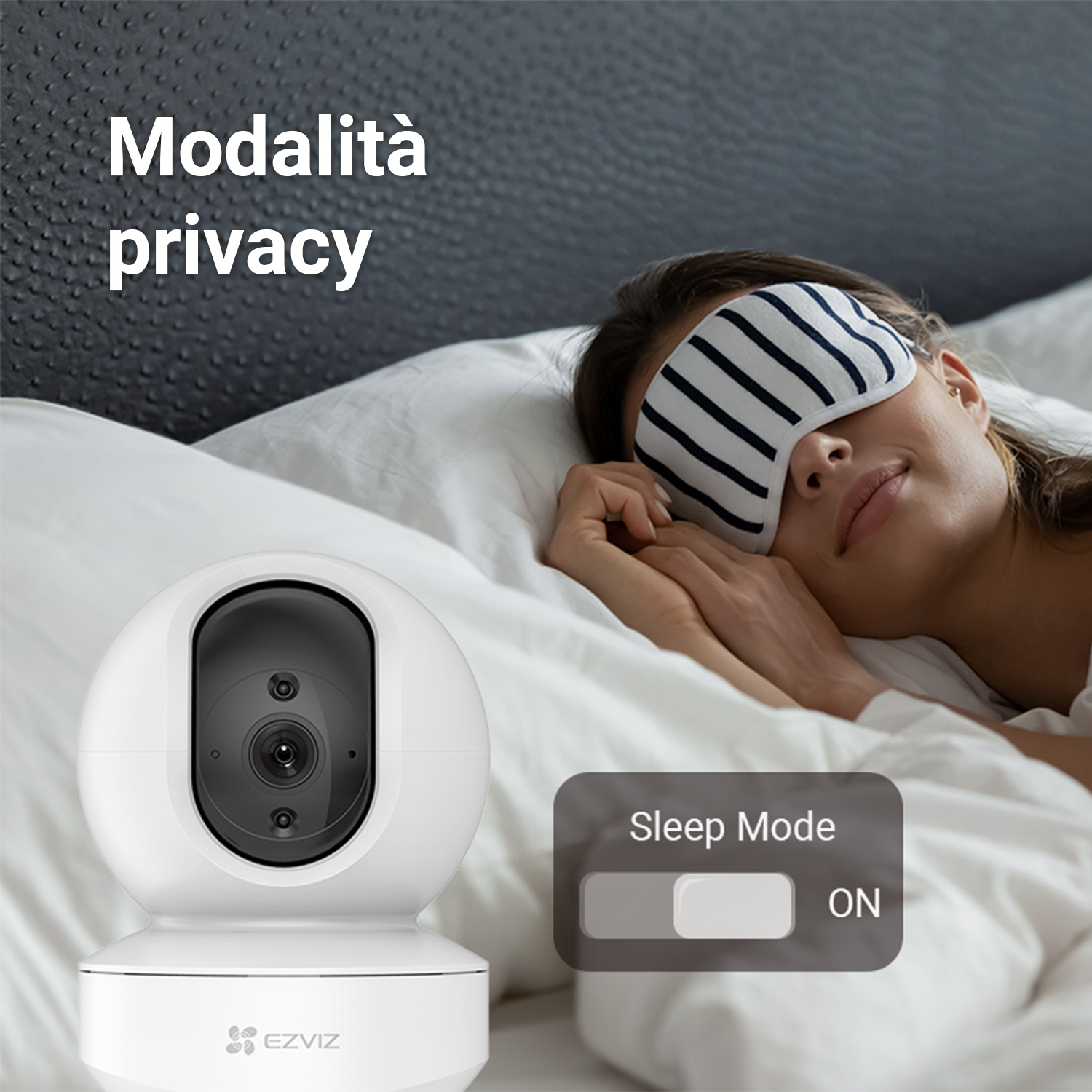 Una donna dorme con una maschera per dormire accanto a una telecamera di sicurezza.