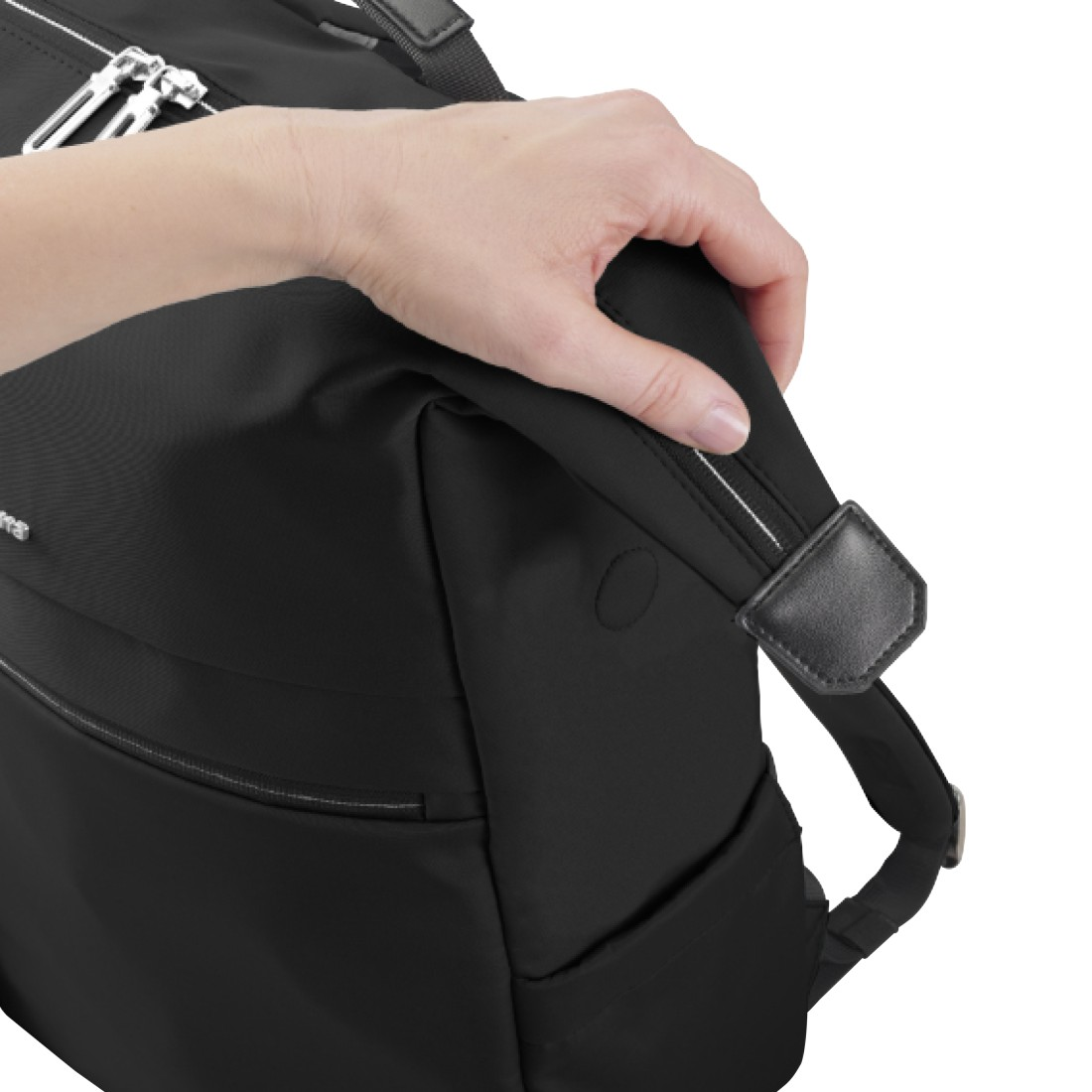 Die Hand einer Person hält den Griff eines schwarzen Rucksacks vor weißem Hintergrund.