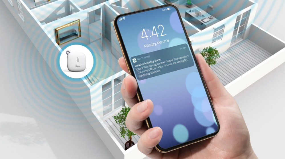 Ręka trzymająca telefon z powiadomieniem o alarmie wilgotności w domu.