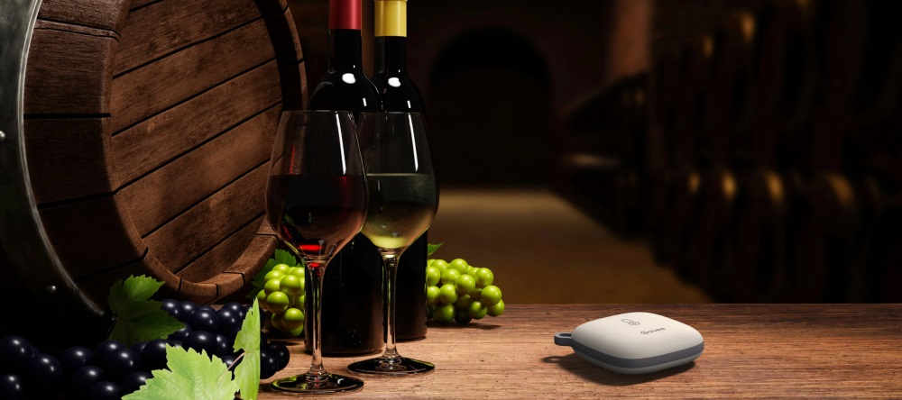 Kieliszki wina, winogrona i produkt na drewnianym stole.