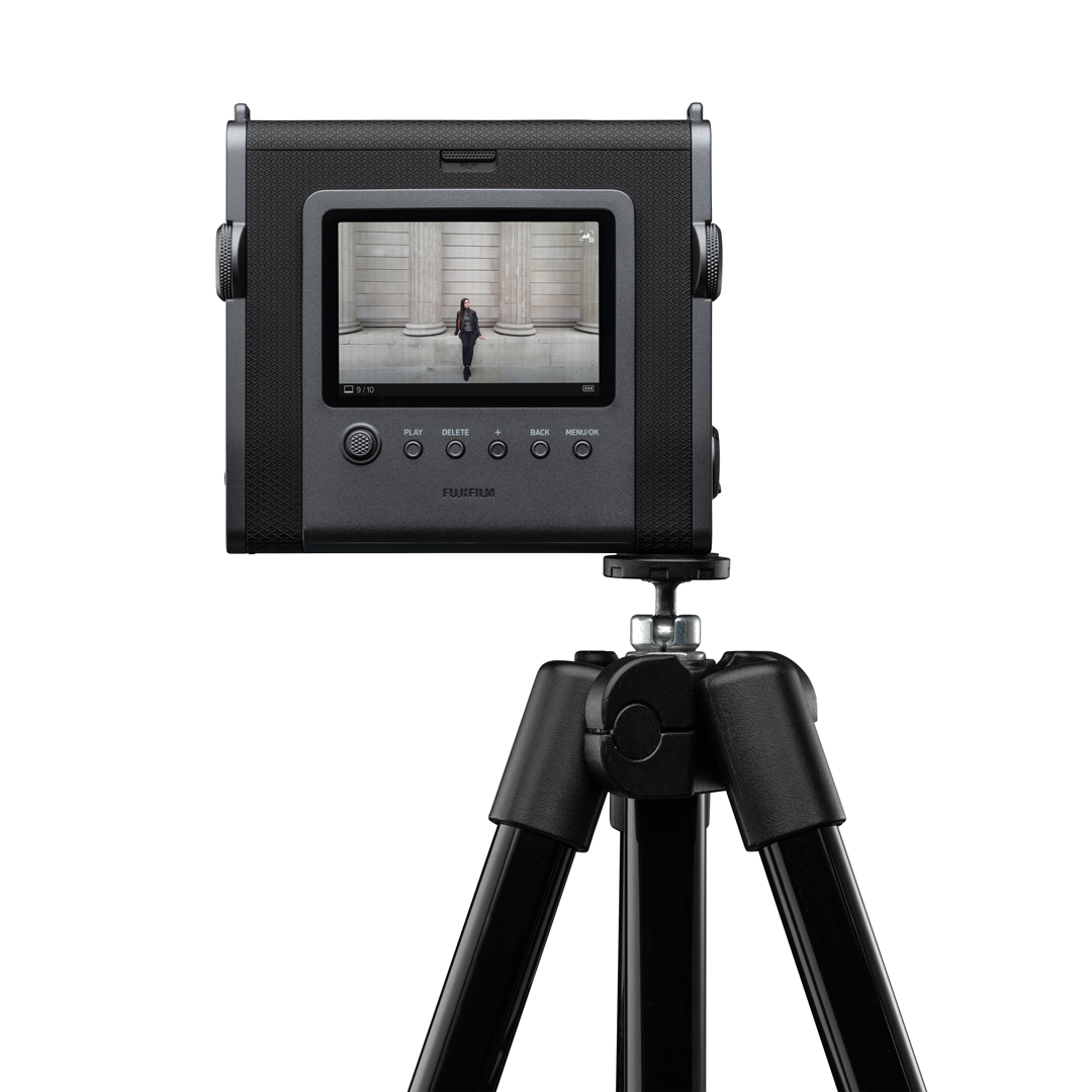 Tripod üzerinde siyah anında fotoğraf makinesi, ekranda görüntü.