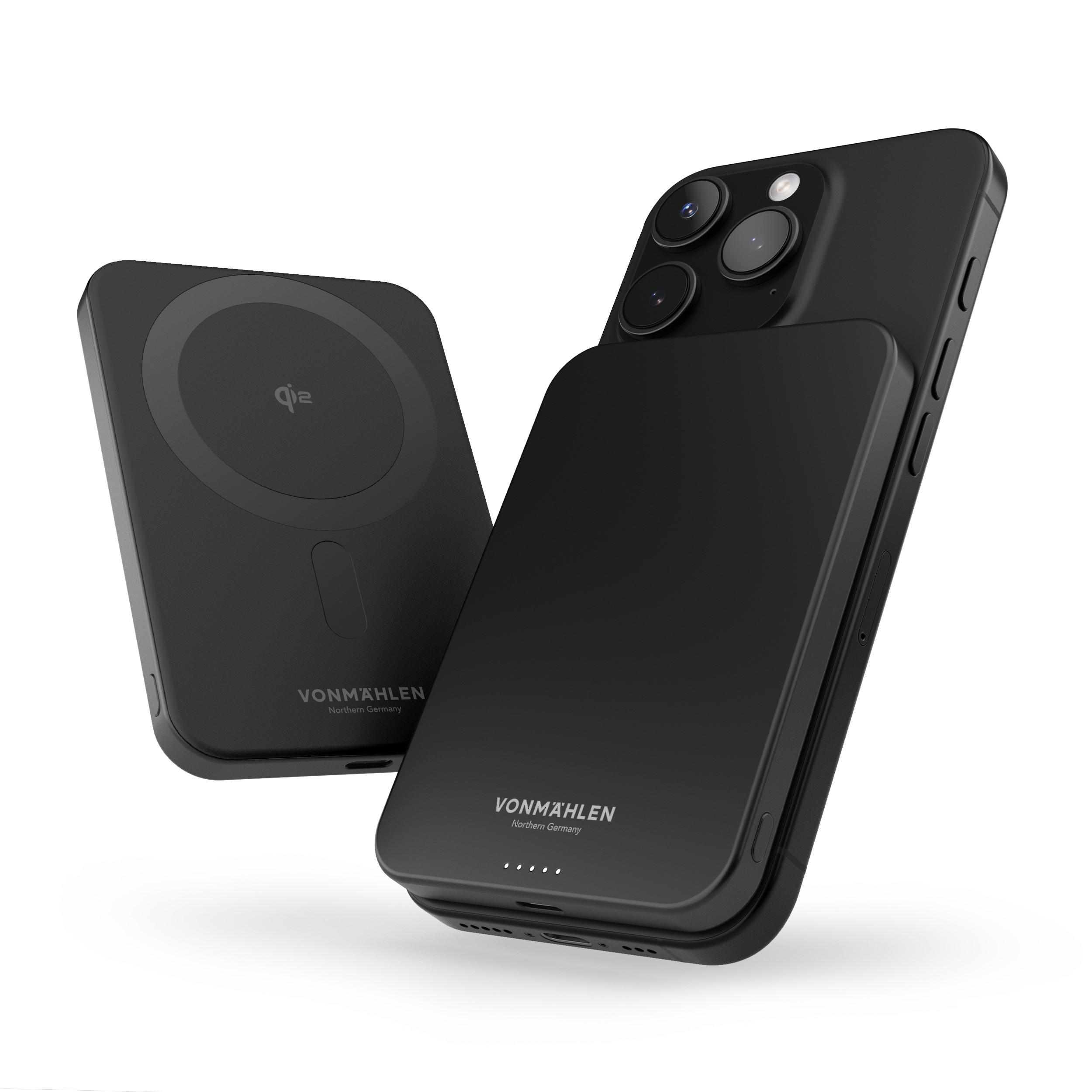 Zwei schwarze kabellose Ladegeräte und ein schwarzes Telefon.