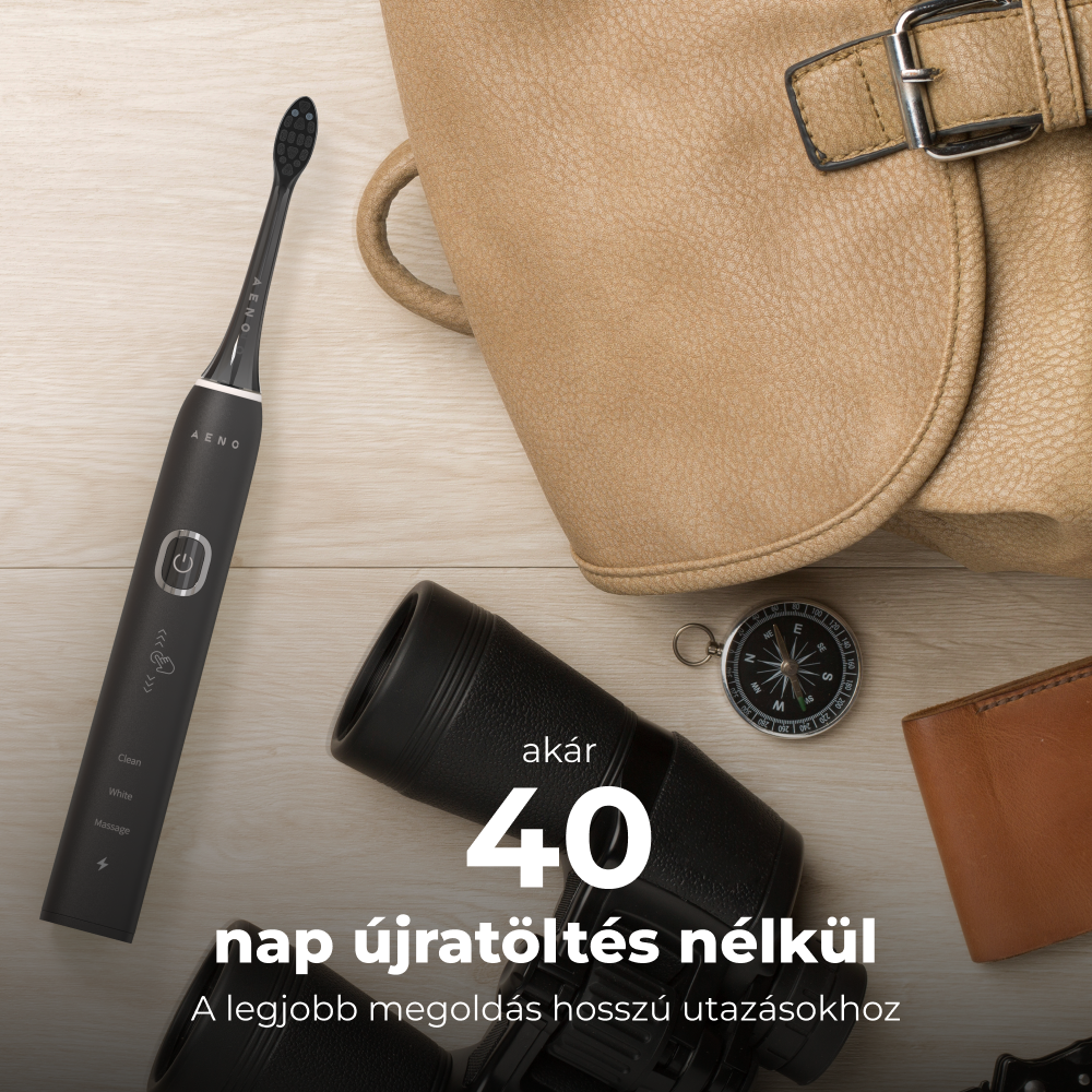 Fekete elektromos fogkefe más utazási tárgyakkal. A háttér egy fa asztal táskával.
