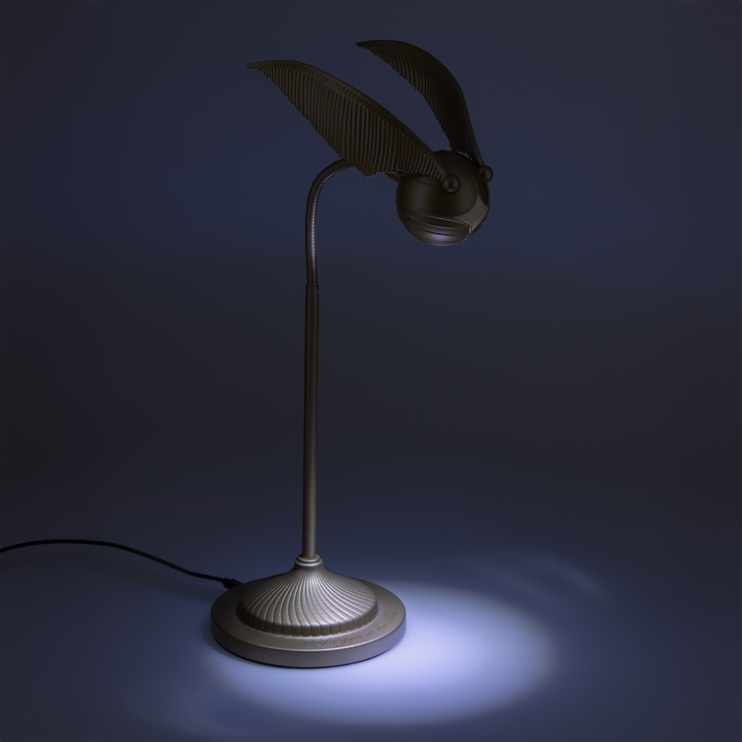 Een Harry Potter Snitch lamp op een donkerblauwe achtergrond.