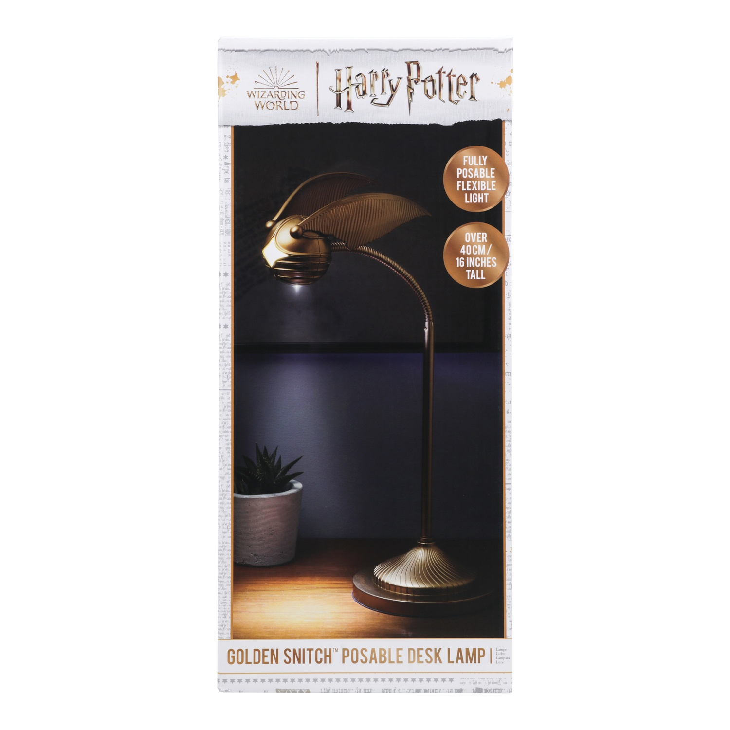 Harry Potter Golden Snitch bureaulamp in doos met plant op houten tafel.