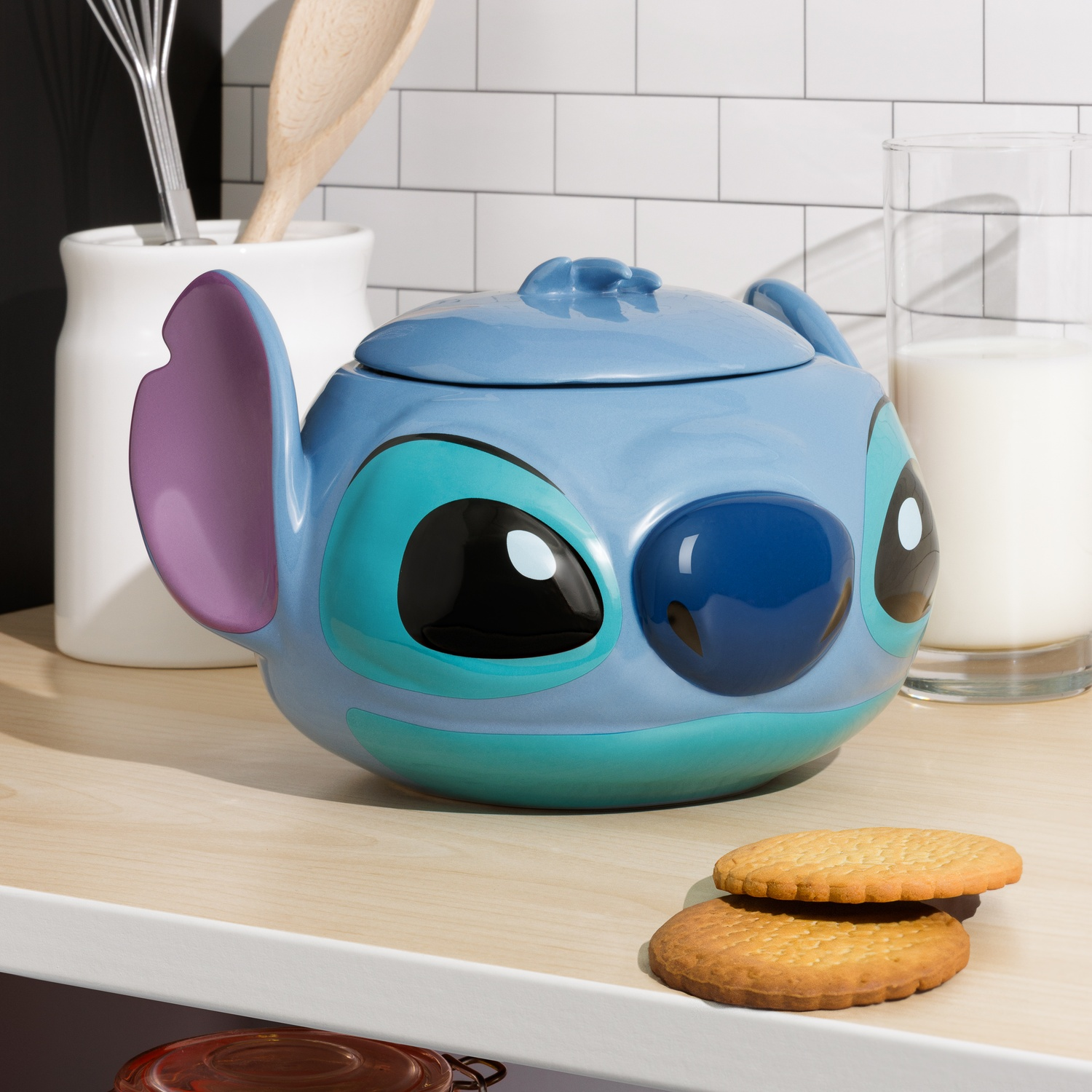 A blue Stitch cookie jar with cookies on a counter.
