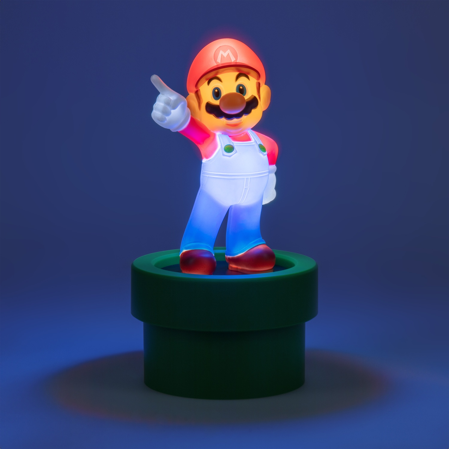 A Mario figurine, standing on a green pipe, pointing, with a blue background.