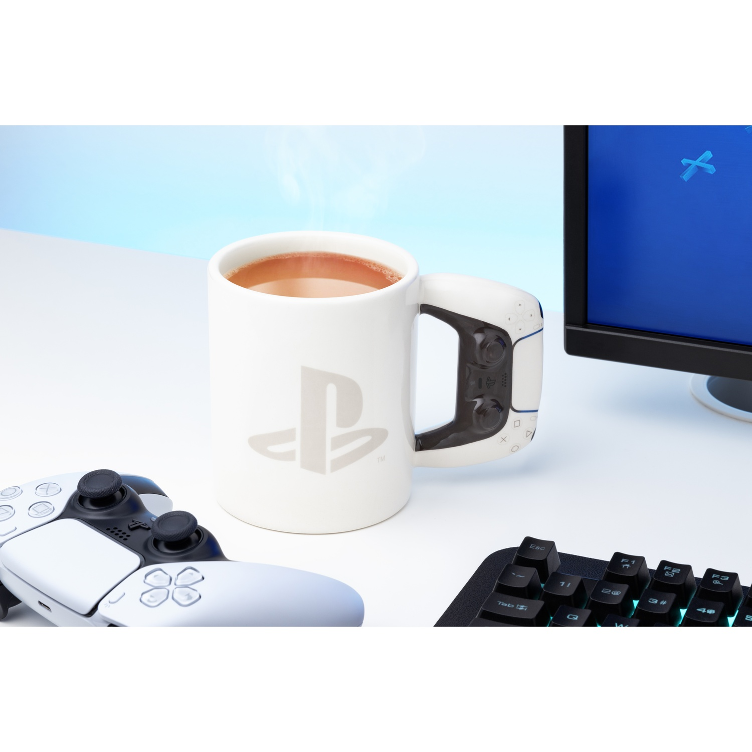 White PS5 mug with PS logo and controller-shaped handle, hot drink inside.