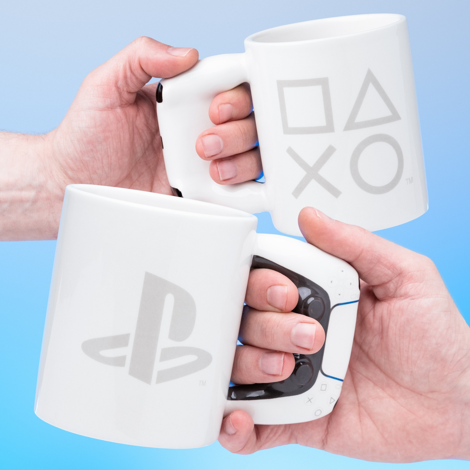 Two white mugs with the PlayStation logo are held by hands, blue light.